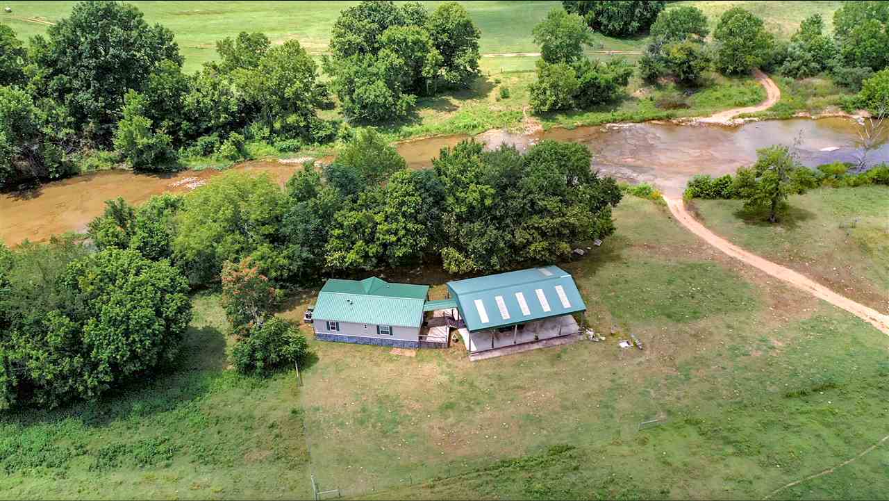 Nice Working Cattle Ranch with South Big Creek running through it, 2 springs on property, several ponds, all fenced and cross fenced, shop, hay barn, 3 bed 2 bath mobile home overlooking creek.Lots of hay to be harvested on this property.About 50% pasture and 50% mature timber.Has a little hunting cabin on hill that could be used for quest.Severl deer stands that will remain.Gated at road but has highway 354 frontage.If your looking for a place to have it all, here you go.Working Coral is Ready!