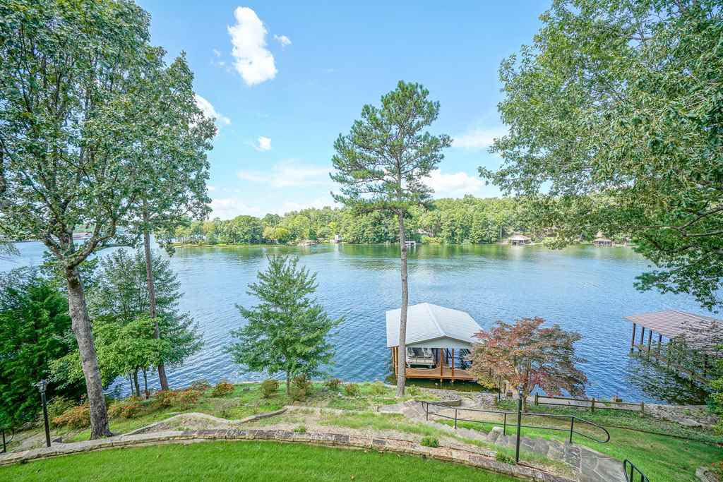 A true 2.1 acre lake estate with 200' on lake, and a 4,830 s.f. four bedroom, four and half bath home. You enter this very special lake property into a broad sweeping circle drive around a wonderfully landscaped courtyard and through a double car wide porte cochere to a four car guest parking and a side entry double garage. Extensive site improvements include two stone patio coves, a family and guest fire pit in a wooded setting of boulders and stone benches, plus a permanent double covered boat slip.
