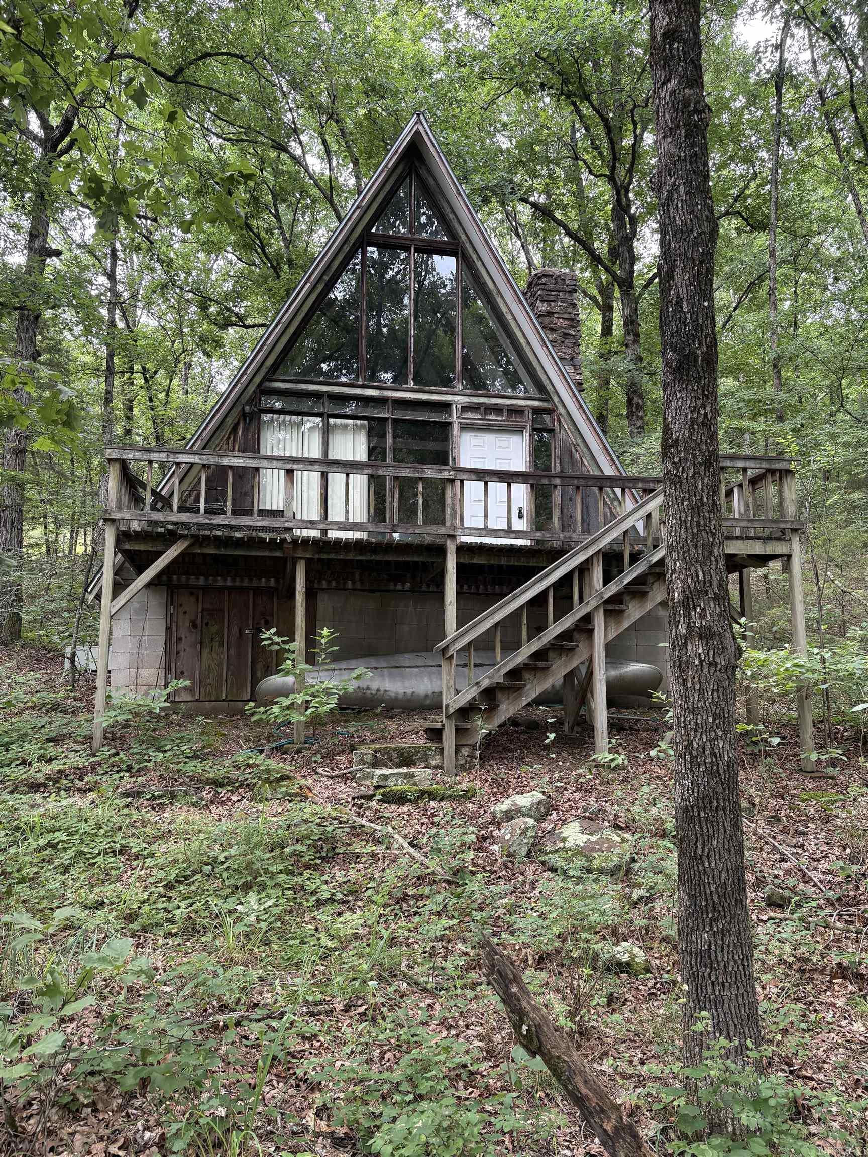 Peace on Big Piney Creek! Nestled against Corp of Engineer land this classic A-frame offers the peaceful retreat you've been dreaming of. Featuring soaring vaulted ceilings, a stunning stone fireplace, and expansive windows that bring the outdoors in this cabin is full of character and ready for new life. If you have been searching for a new project this may be you next renovation! This unique property is ready for your vision! Call today!