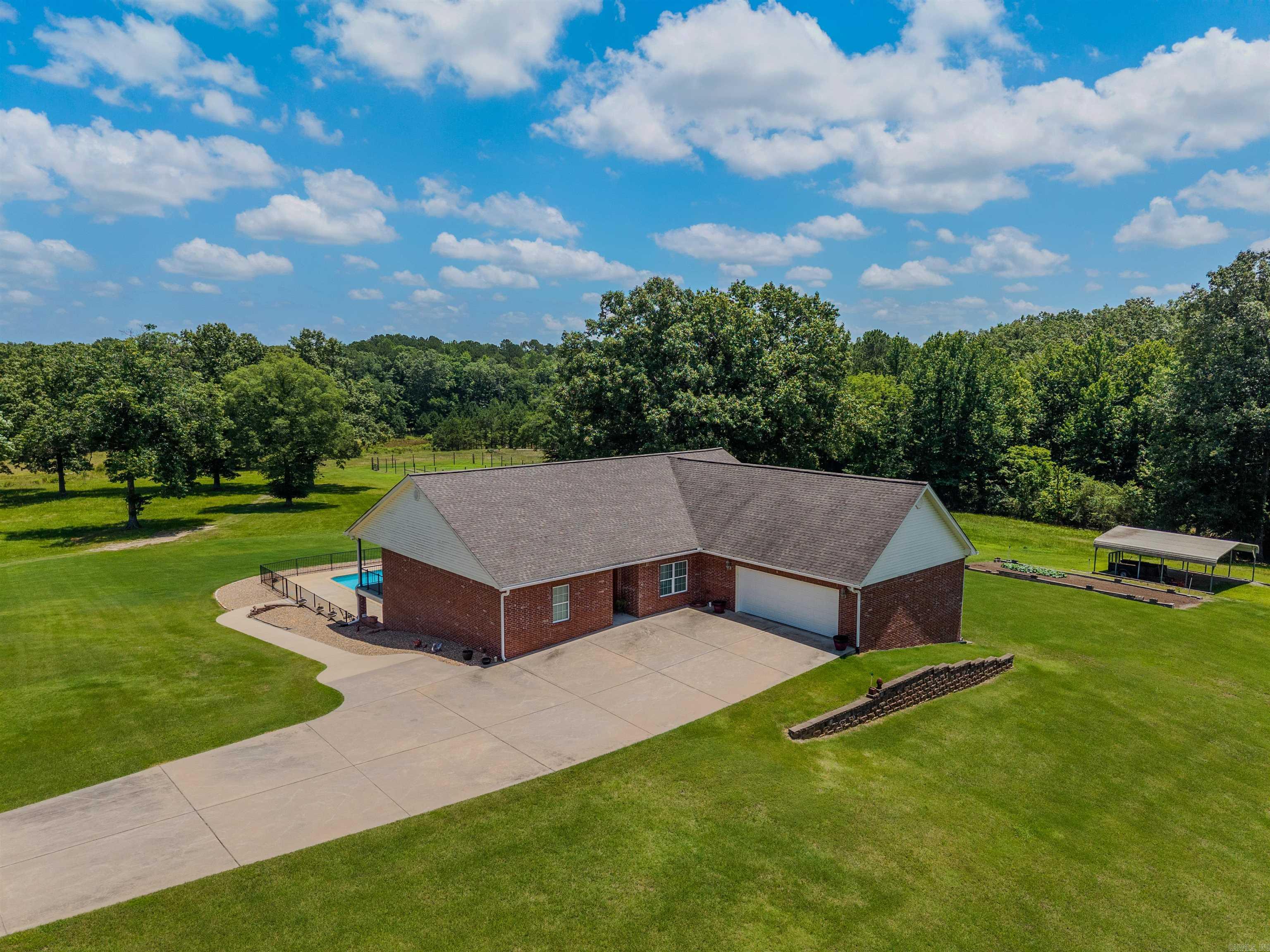 18 Acres. Over 4,600 Sqft. Benton Schools. Outside City Limits. Only 8 minutes from the Saline County Courthouse Square! This 4 bed, 3 bath home has something for everyone. The main level features 3 bedrooms, including the primary suite. Walk through the front door into a spacious open living and dining area with plenty of room for entertaining. The kitchen features a huge granite breakfast bar and abundant cabinet space. The primary bath offers extensive cabinetry and a walk-in shower. Downstairs you’ll find a 4th bedroom, full bath, complete second kitchen, large pantry/storage area, huge bonus/game room, and a safe room. Outside is where this property truly shines. Enjoy your pool and large double-decker patios overlooking 18 beautiful acres. The land offers a mix of open pasture and mature hardwoods. An established garden area with water hookups is ready for your personal touch. The home is also equipped with a natural gas backup generator. Also available is an additional 3 bed, 2 bath home located on the property. Details available upon request. Agents see remarks.