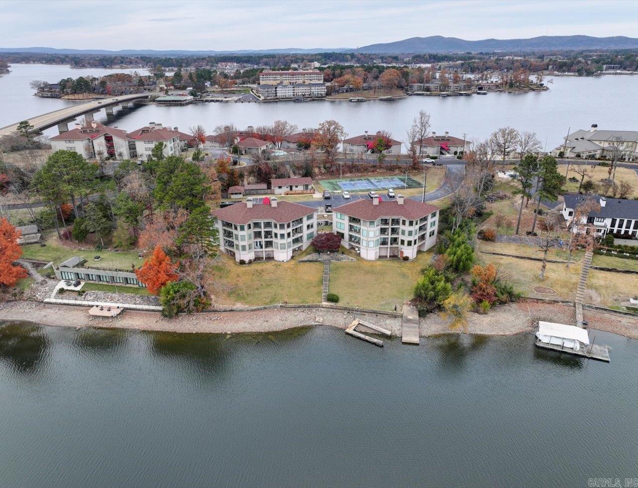 Nightly rentals allowed with covered boat slip and lift, offering excellent income potential or the perfect lake getaway. This completely remodeled, turnkey condo is sold fully furnished and ready for immediate rental or personal enjoyment. The 1,648 SF open, light-filled layout features beautiful lake views. Updates include furniture, flooring, appliances, lighting, plumbing fixtures, solid-core doors, and remodeled bathrooms with soaking tub and upgraded showers. Major improvements include HVAC (2024), roof (2024), and water heater (2022). Relax on the private deck and enjoy easy, protected lake access. Convenient to Hot Springs dining, shopping, and entertainment. Ideal investment, second home, or just get away, relax, and enjoy the lake. Motivated seller—bring offers.