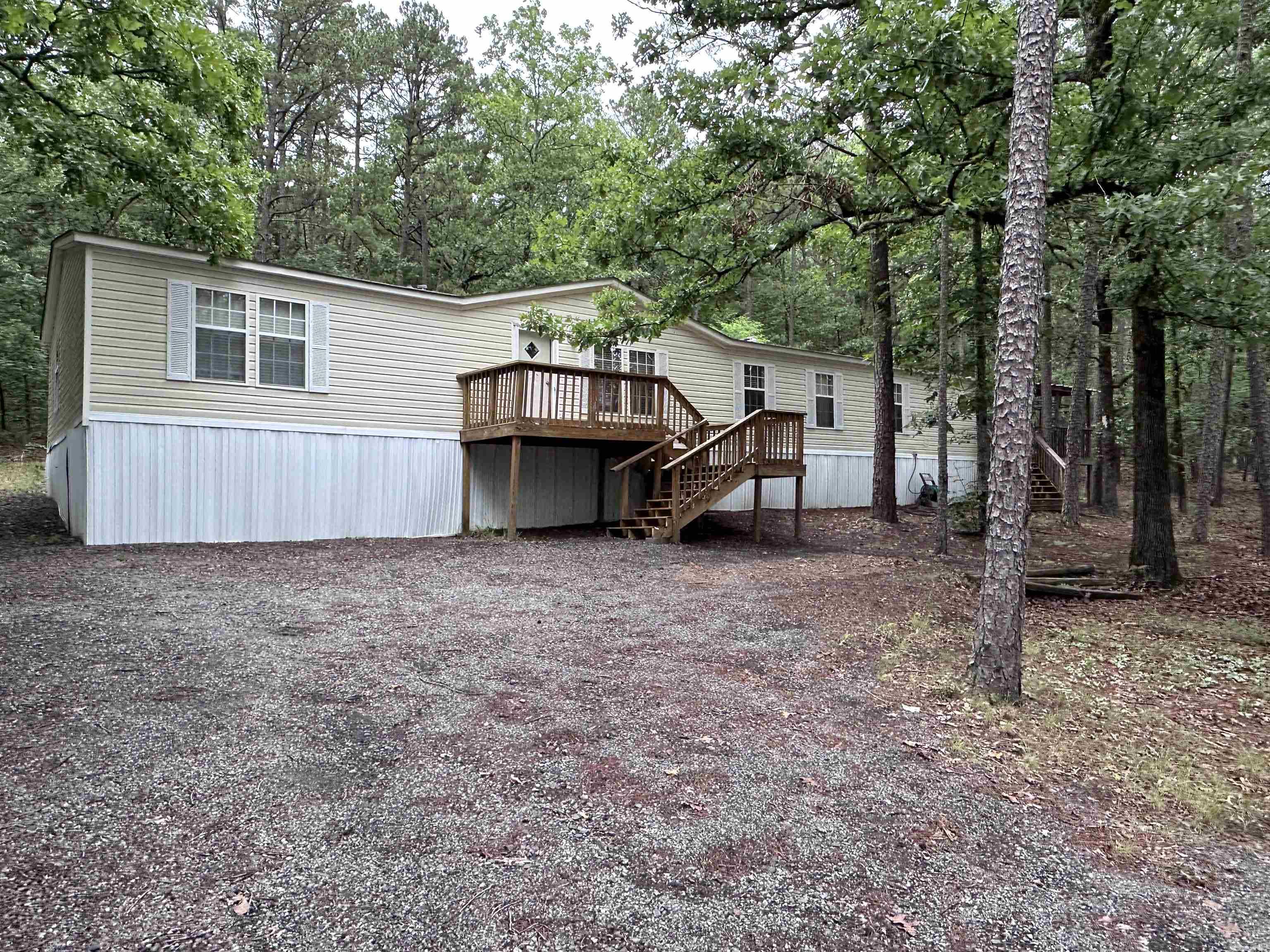 Spacious and inviting 4 bedroom, 2 bathroom double wide located near beautiful Greers Ferry Lake! This home offers plenty of room for family and friends with two separate living areas, perfect for entertaining, relaxing, or creating a game room or home office space. The open kitchen features abundant cabinet space, a dining area, and a convenient breakfast bar for casual meals and gatherings. Step outside and enjoy the peaceful setting from the back porch or unwind on the covered side porch, ideal for grilling and outdoor entertaining year-round. The primary bedroom offers additional space to be used as a sitting area or home office. Whether you’re looking for a full-time residence, lake getaway, or investment opportunity, this property offers comfort, space, and easy access to all the recreation Greers Ferry Lake has to offer.