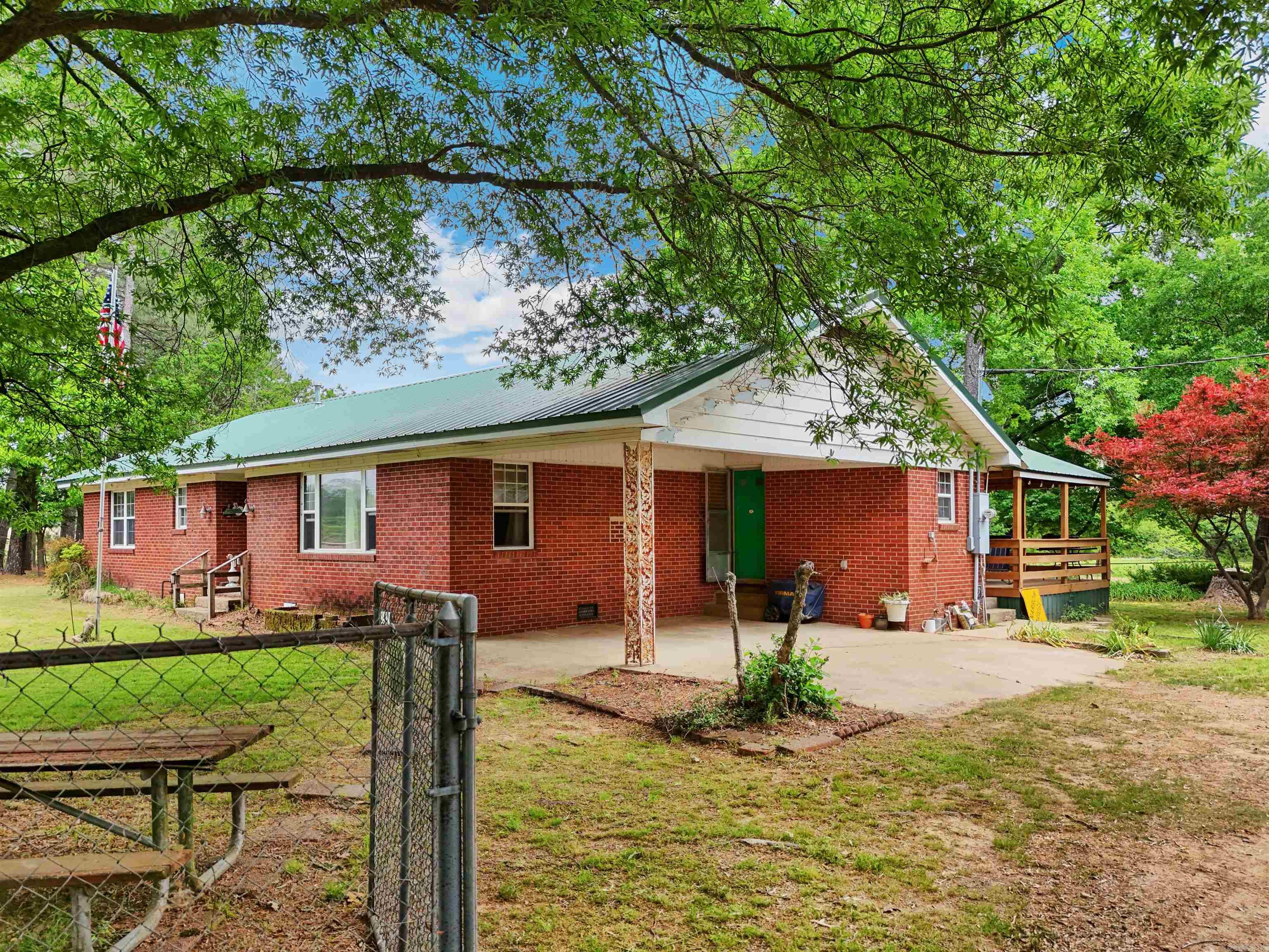 Opportunity awaits with this 3-bedroom, 1-bath brick home situated on approximately 10 beautiful acres! Being sold as-is, this fixer upper offers endless potential for investors, homesteaders, or buyers looking to create their dream country property. The home features a newer roof and hot water heater, giving you a solid start for renovations and updates.  Outside, the property is packed with amenities including a barn, two storage buildings, lean-to, cross fencing, a pond, and two wet weather creeks running through the land. There is also a concrete RV pad complete with its own electric meter, outlets, water line, and septic system — perfect for guests, additional living space, or RV hookup convenience.  With a mix of open space, water features, and functional improvements already in place, this property offers the rare chance to own acreage with tons of potential and room to grow. Be sure to check out the aerial drone video to catch a peak at all the wildlife! Agents see remarks.