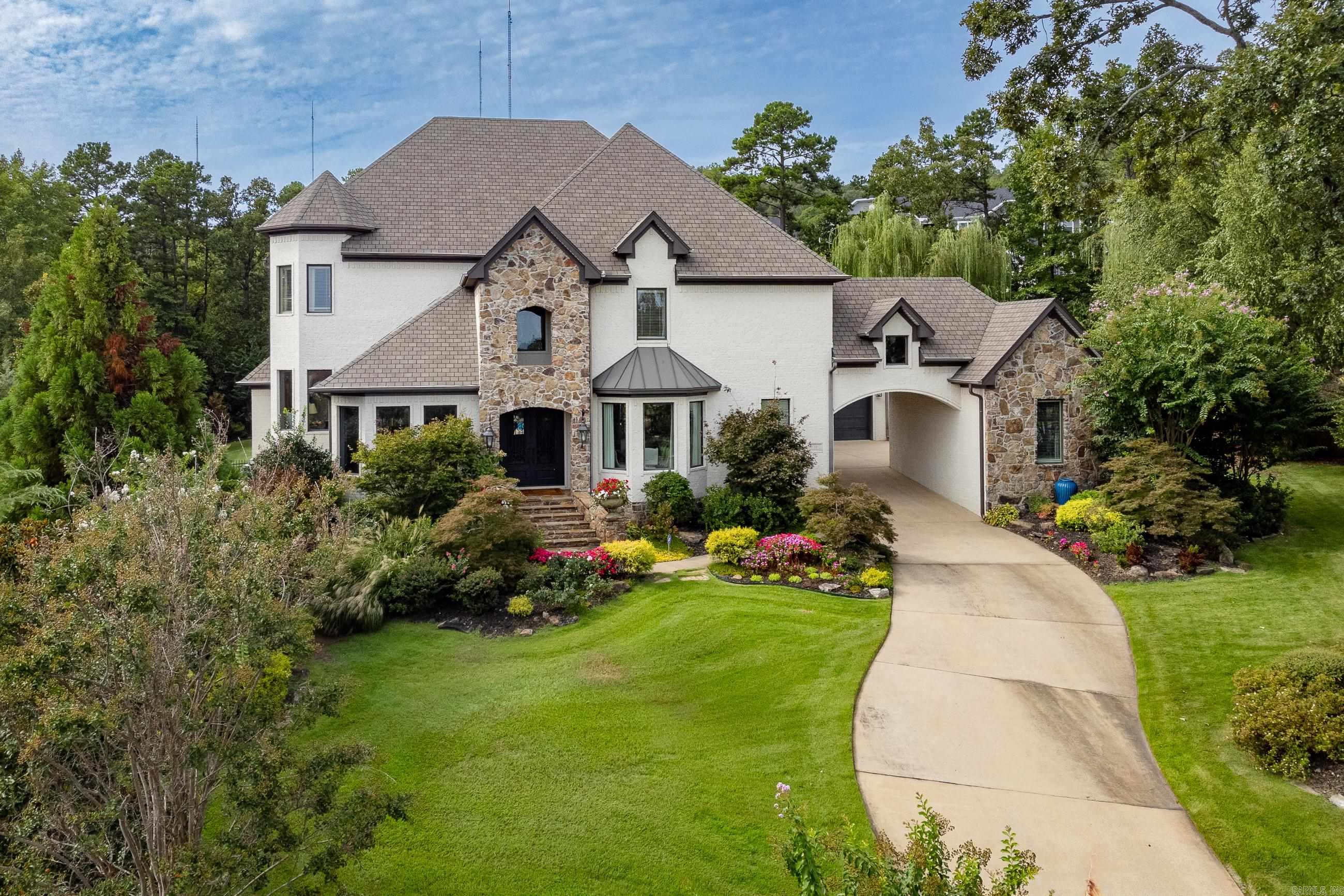 Gorgeous family home situated on beautifully landscaped lot in gated Deauville. Warm HDWD floors, stunningly tall ceilings and windows overlooking the covered outdoor living space with pool, lush plantings and backyard pond. Perfect floorplan with Great Room, formal and informal dining areas, huge kitchen with Jenn-Aire appliances, study and separate office. Luxurious primary suite with separate sitting area and huge bath & closet. Also main level guest suite with access to pool & patio. Plenty of room upstairs for fun in the family den adjacent to the large Theater room w/wet bar. Two spacious guest BDRMS with shared bath, large en-suite guest BDRM and large work/craft/storage area. Two car garage with golf cart garage as well as another one car garage and parking pads. This house has it all. Come See!