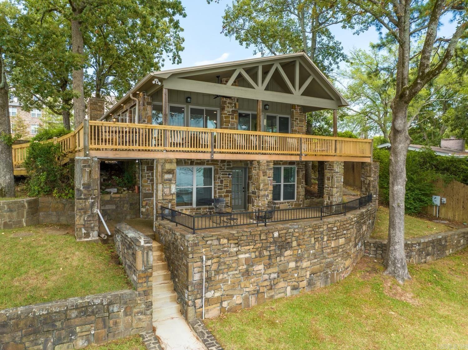 Must see this Stunning 4-bedroom lake house on Lake Hamilton with expansive views. Recently renovated with a brand-new kitchen,flooring, and bathrooms. Private boat dock for the perfect lakeside experience. Versatility at its finest! This updated lake house not onlythrives as a successful nightly rental but also offers the perfect setting for a cozy and wonderful family lake home. A win-win for bothinvestment and making lasting memories. Prime location alert! This gem boasts not only one of the best views on Lake Hamilton butalso strategically sits on prime waterfront and land.