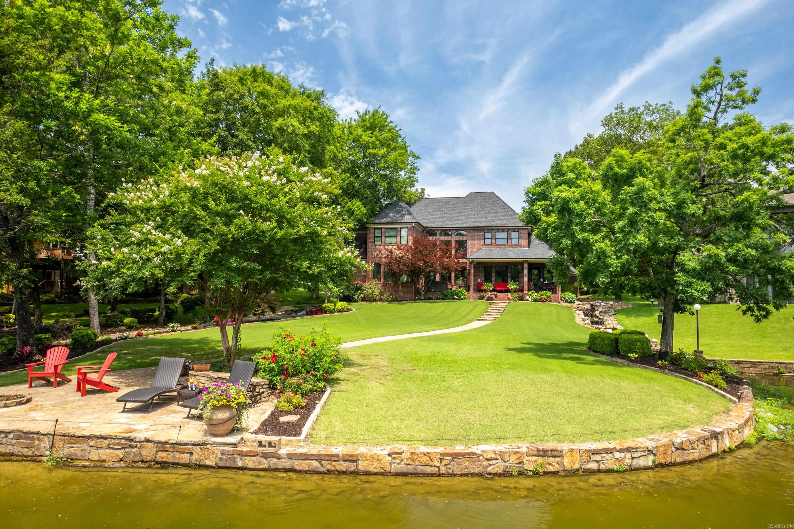 Welcome to your dream lake home, offering exquisite lakefront living in the prestigious Stonegate Shores! Discover an exceptional opportunity to own a beautifully appointed 5-bedroom, 3.5-bath waterfront estate on the serene shores of Lake Hamilton. Set on a meticulously manicured, level lot in the prestigious gated community of Stonegate Shores, this home blends sophistication, comfort, and the ultimate lake lifestyle.  Enjoy a spacious main-level primary suite, formal dining room, great room, separate living room, and a gourmet eat-in kitchen designed for both everyday living and entertaining. An oversized 3-car garage offers plenty of space for vehicles and lake gear.  Step outside to your private oasis with a professionally landscaped backyard, tranquil water feature, fire pit, and direct access to a 2-slip covered boat dock in a peaceful no-wake cove with boat launch—perfect for swimming, boating, or simply relaxing.  Recent upgrades include new insulated windows and a new roof (Dec 2023). Just minutes from all that Hot Springs has to offer, this is lakeside luxury at its finest! Schedule your showing today!
