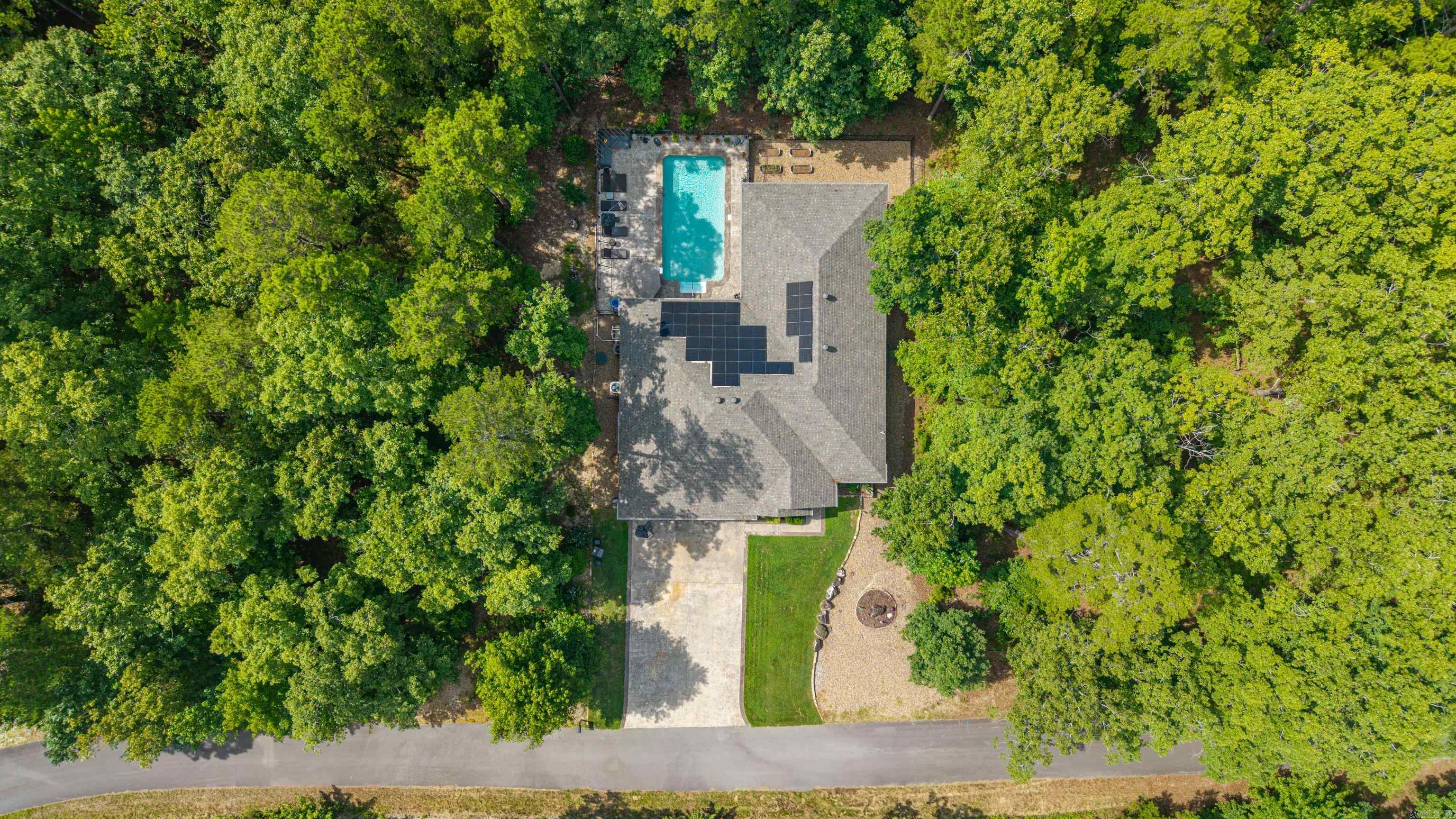 Private backyard oasis featuring a heated saltwater pool, pergola, stamped concrete patio, raised garden beds, and wrought iron fencing. This move-in ready home offers an open-concept floor plan designed for entertaining with a spacious living area, propane fireplace, and barn doors leading to an impressive game room complete with a custom bar, beverage fridge, icemaker, and built-in sound system. The primary suite is a true retreat with a spa-like bath featuring a walk-in shower, soaking tub, double vanities, private water closet, and oversized walk-in closet with direct access to the laundry room. Two guest bedrooms share a spacious bath with a walk-in shower. Enjoy resort-style outdoor living with a heated saltwater pool featuring an upgraded liner and dedicated heat pump for extended seasonal use. Relax under the pergola or entertain poolside in the beautifully landscaped backyard. Additional features include a 3-car garage with insulated doors, epoxy floors, ample storage, solar panels for energy efficiency, modern finishes, low-maintenance living, and a convenient location. A perfect blend of comfort, style, and functionality.