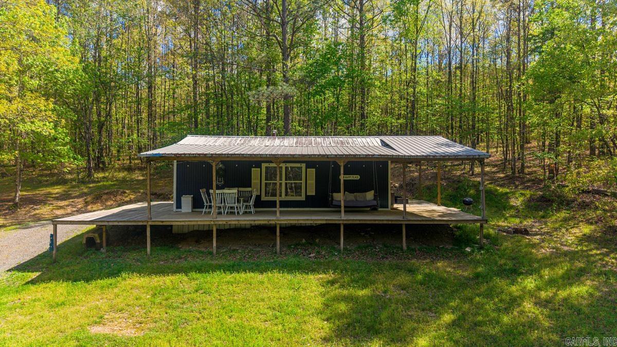 This Airbnb is tucked into 10 acres of serene, wooded landscape, this charming rustic cabin offers the kind of escape people daydream about and book again and again. Perched on a hill, the cabin features a spacious wraparound porch perfect for morning coffee or evening unwinding while listening to the soothing sounds of Ten Mile Creek below. A well-maintained, easy walking trail leads you down to a private swimming hole, creating a natural centerpiece for relaxation and recreation. Inside, the cozy layout includes a comfortable bedroom, a welcoming living room with a sleeper sofa, and a charming sleeping loft that’s ideal for kids or extra guests. Secluded yet inviting, this property is perfectly suited for couples’ retreats or family getaways, with a proven track record of steady year-round Airbnb income at $20K annually. Fully furnished, Furniture and Amenities stay with the cabin. Close to Hot Springs and Ouachita River access. Buy as an investment or as a personal oasis for yourself. Just minutes from I-30 and 8.5 miles from the future Buc-ee's Travel Center in Benton Arkansas. Located in the Glen Rose School District