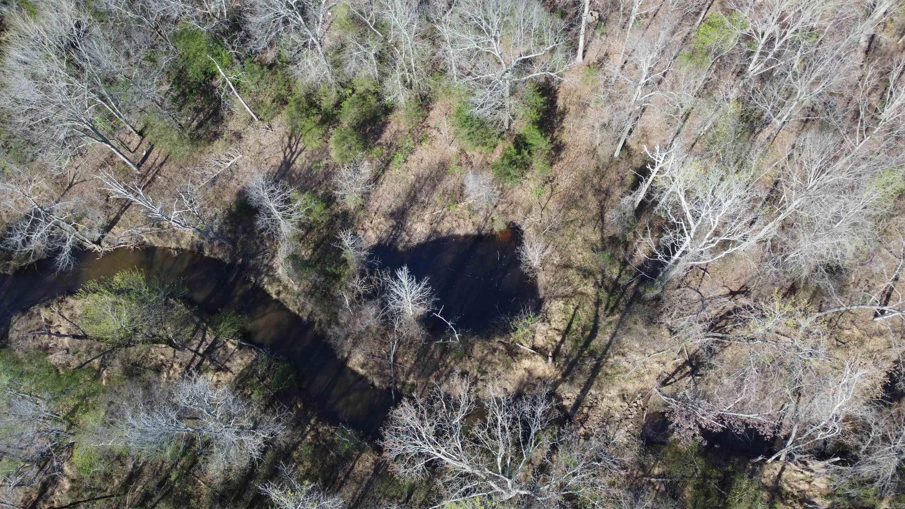 Ozark Foothills Retreat is a quiet unrestricted tract located just northwest of Bradford in Jackson County with convenient Jackson County Road 5 frontage. Heavily wooded with mature hardwoods and eastern red cedar, the property offers privacy, natural beauty, and excellent habitat in the foothills of the Ozarks. Much of the tract features quality soils, while native stone outcroppings add character and scenic appeal.  A seasonal stream flows near the front of the property, with a small pond just west of the creek, creating attractive water features for wildlife and future homestead use. Existing roads and driveway areas will need repair and cleanup, allowing the next owner to shape the property into their own vision.  Known for abundant deer, turkey, and native wildlife, this tract offers excellent recreational upside. With timber stand improvement, trail development, and strategic food plot areas, it could become an exceptional hunting getaway, homesite, or weekend retreat with nearby rural water access.