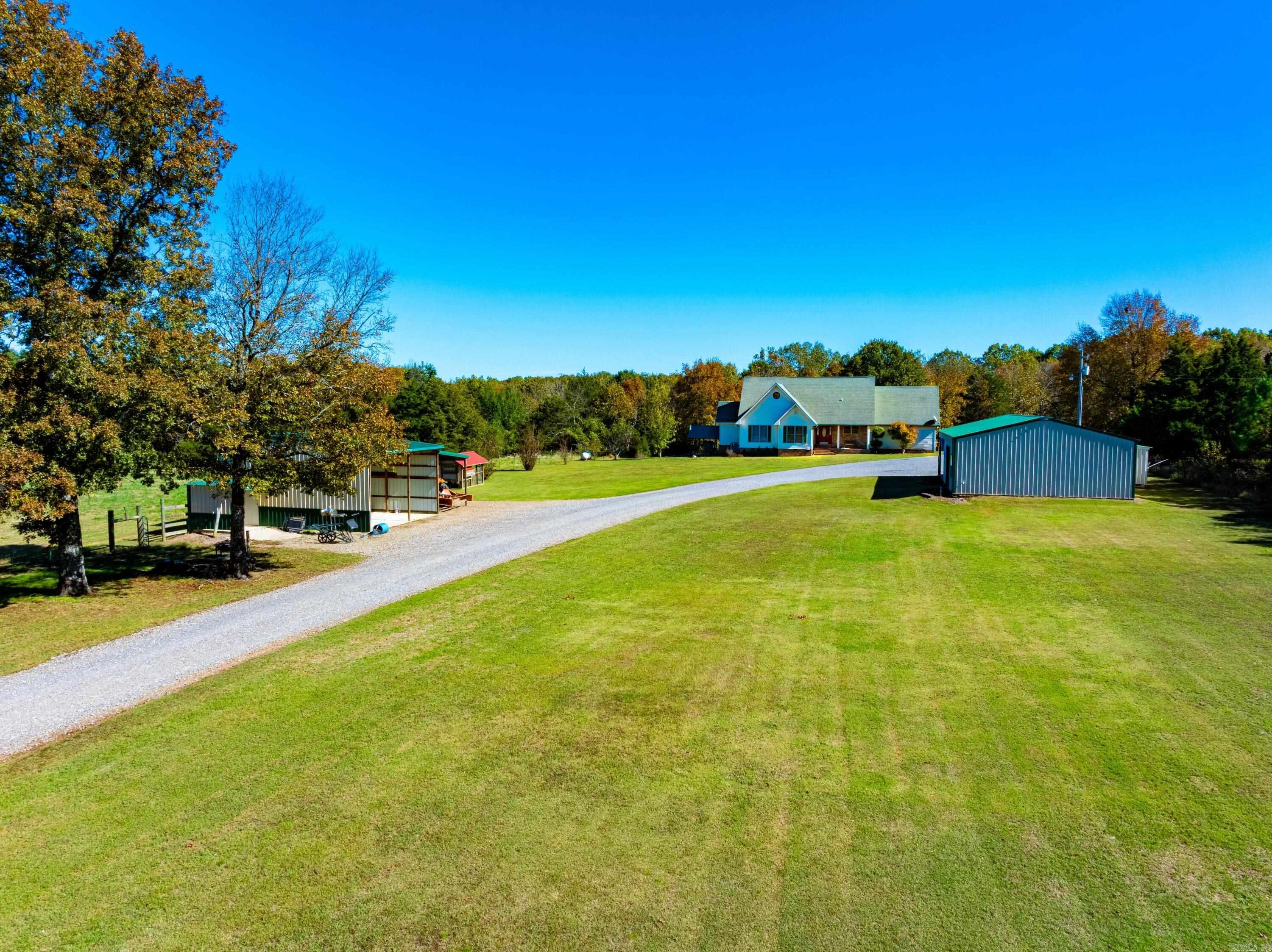 Offering approximately 240 +/- acres of impeccably managed land, a beautiful home, multiple outbuildings, and an unbeatable location just minutes from Searcy, Arkansas, this Ozark estate stands in a class of its own. The home sits privately among mature timber and welcomes you with a gorgeous front porch and a warm, cabin-style interior. The main level features three bedrooms, two full bathrooms, a large kitchen, and a comfortable living room with glass doors leading to a quiet back deck overlooking woods and abundant wildlife. A log-accented loft above the living area provides additional space and can be closed off for privacy. A spacious mudroom leads to the garage, with stairs accessing a heated and cooled bonus room ideal for an office or extra sleeping space. Total heated and cooled living space is approximately 2,337± sq ft. Outside, a fully enclosed shop (currently used for a taxidermy business), a lean-to for vehicle parking, and an additional machine shed offer excellent functionality. Some of the most manicured and well-managed recreational and hunting acreage in the area. Immaculate fields, food plots, hay fields, and an outstanding trail systems with a year round creek.