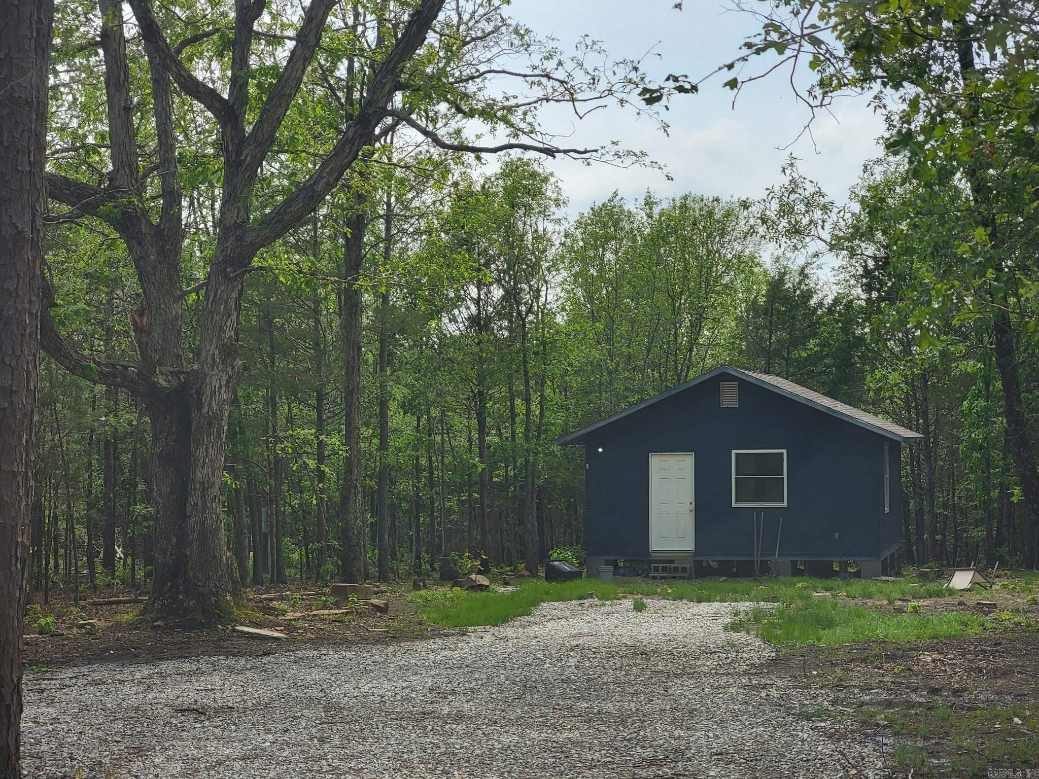 Great price! Motivated seller! Looking for a beautiful mountain getaway with nightly rental potential, maybe a hunting retreat, or a second home? This cabin is ideally located in the Ozarks just a few miles from the music, shops, and eateries in world renown Mountain View, the Folk Music Capitol of the world! With 18+/- mostly wooded acres MOL and a wet weather spring, this property is a nature lovers dream with an abundance of whitetail deer, wild turkey, birds, and small game. Love to fish? Enjoy World Class Trout fishing on nearby White River! Love hiking and trail riding? Stone County has tens of thousands of acres of beautiful Ozark National Forest. This area offers so much to enjoy whether you love to be outdoors or to simply relax in a peaceful quiet setting. The setting is so appealing, with an old wagon trail, garden area, native stone, and the cabin is ready to make your own. It is wired, sheet rocked, and has a public water meter, but water lines have not yet been run. A septic tank will be required and a new survey, provided by the seller, as this is half of a larger tract with additional acreage available for sale. What a great opportunity to own a cabin with acreage!