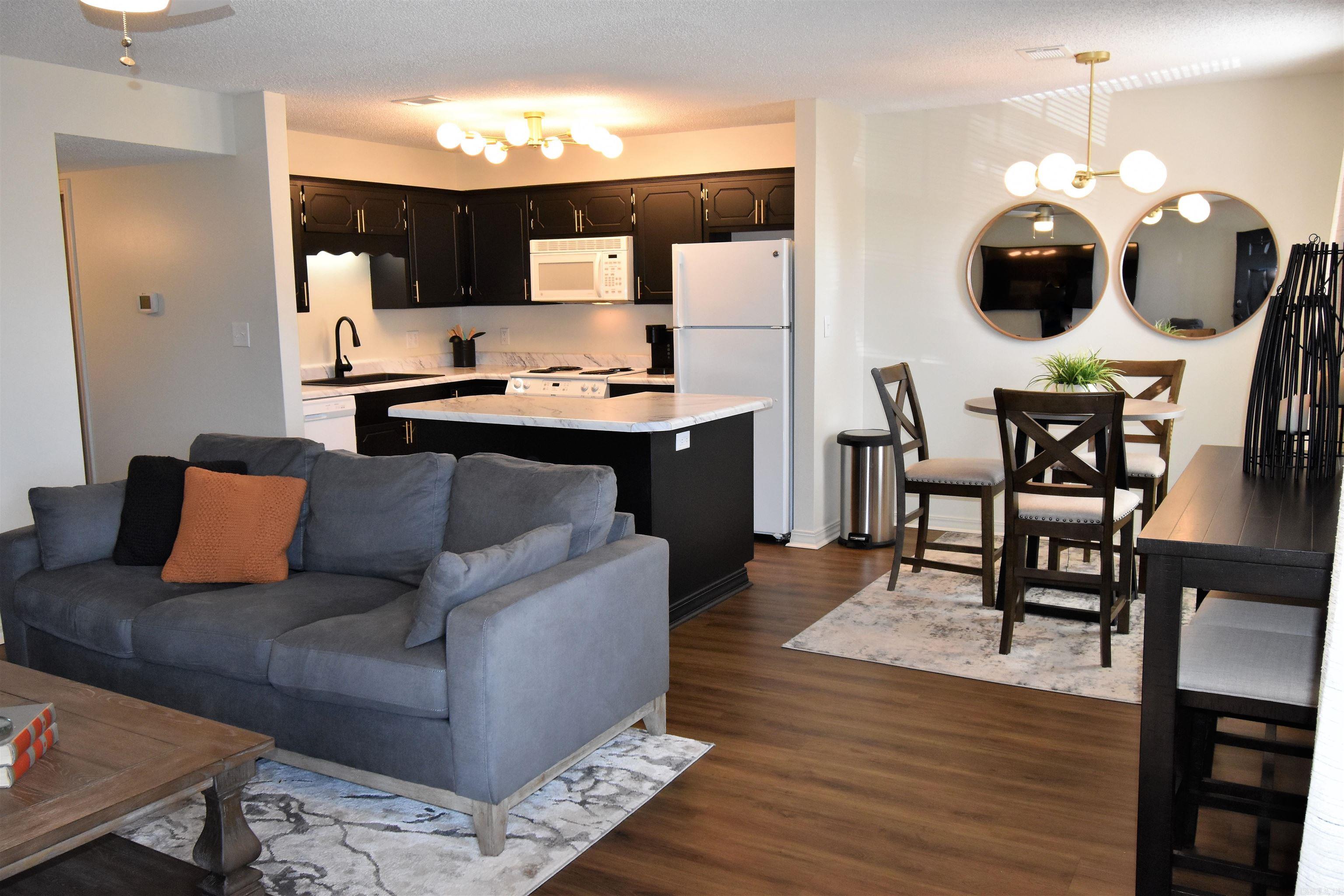 FULLY FURNISHED & situated directly across the street from Unity Health, this move-in-ready unit is an unbeatable location for medical professionals, travel nurses, or anyone seeking a turnkey home or investment property in Searcy. Inside, an inviting open-concept layout seamlessly connects the spacious living room to a chef-inspired kitchen—complete with sleek black cabinetry, rich brass hardware, marble-look countertops, and a central island ideal for entertaining. Warm wood-look flooring flows throughout the home into the thoughtfully styled bedrooms and fully updated bathrooms featuring chic round mirrors and modern fixtures. Complete with an in-unit washer and dryer, comfortable designer furnishings, and stylish decor, everything is already taken care of for you. Beyond your front door, enjoy unmatched accessibility with River Oaks Golf Course right around the corner, along with Searcy’s best shopping, dining, and entertainment just minutes away. Whether you're looking for a hassle-free primary residence or a seamless rental property, Unit #52 delivers style and value in one complete package.