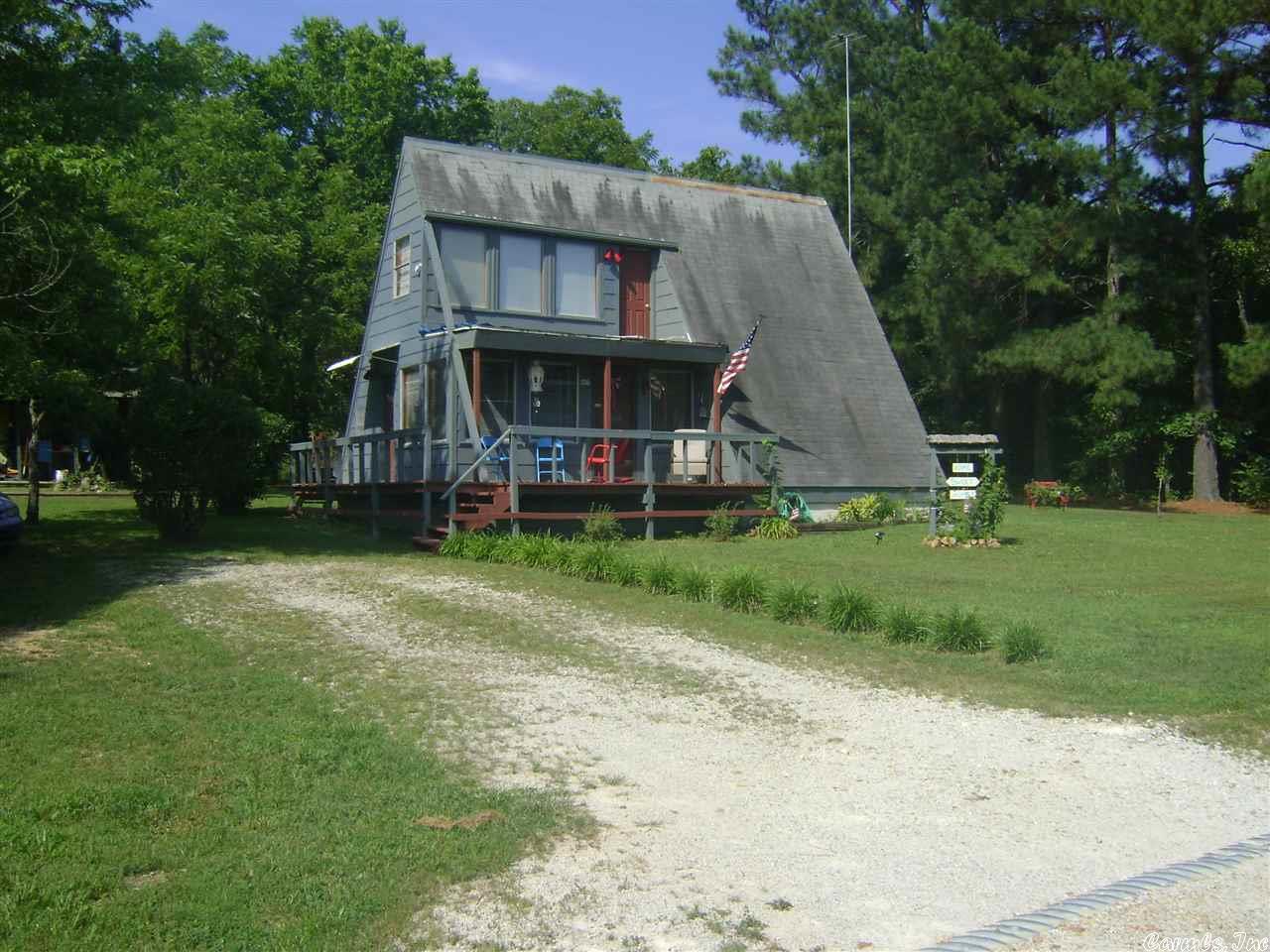Affordable A Frame house with a lake view on a level lot.  It has one bath and 2 bedroom with a balcony upstairs to enjoy the lake view.  Comes with gas log thermostatic control fireplace.  It has hardwood and carpet floor coverings. You can drive your golf cart or side by side to do your shopping in town.  It is a nice get away to relax from the city and enjoy seeing wildlife in your yard, play golf or use the area lakes.  Come see it today before this house is sold.  It will not last at this price.