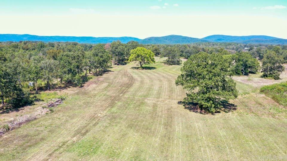 Nestled in the stunning Ouachita Mountains, this exceptional 76-acre tract offers the perfect blend of natural beauty, functionality, and opportunity. The property features a mix of partially cleared land and towering mature timber, creating an ideal balance of open space and privacy. A newly constructed gravel road leads you into the heart of the property, where a shop building is already in place—complete with well, septic, and utilities—providing an excellent head start for your vision.  With ample level ground near the entrance, this property presents a prime opportunity for development as an RV park or campground, catering to those seeking a retreat in nature without sacrificing modern conveniences. Guests can enjoy evenings around the campfire or spend their days exploring the extensive trail system—perfect for UTV riding, hiking, biking, horse back riding, or leisurely walks.  The land is rich with natural water features, including year-round Bolen Creek bordering the entire east side—offering potential swimming spots and tranquil views.  A pond adds to the charm, ideal for fishing or evenings enjoying the scenery. SEE DOCUMENTS FOR ADDITIONAL REMARKS