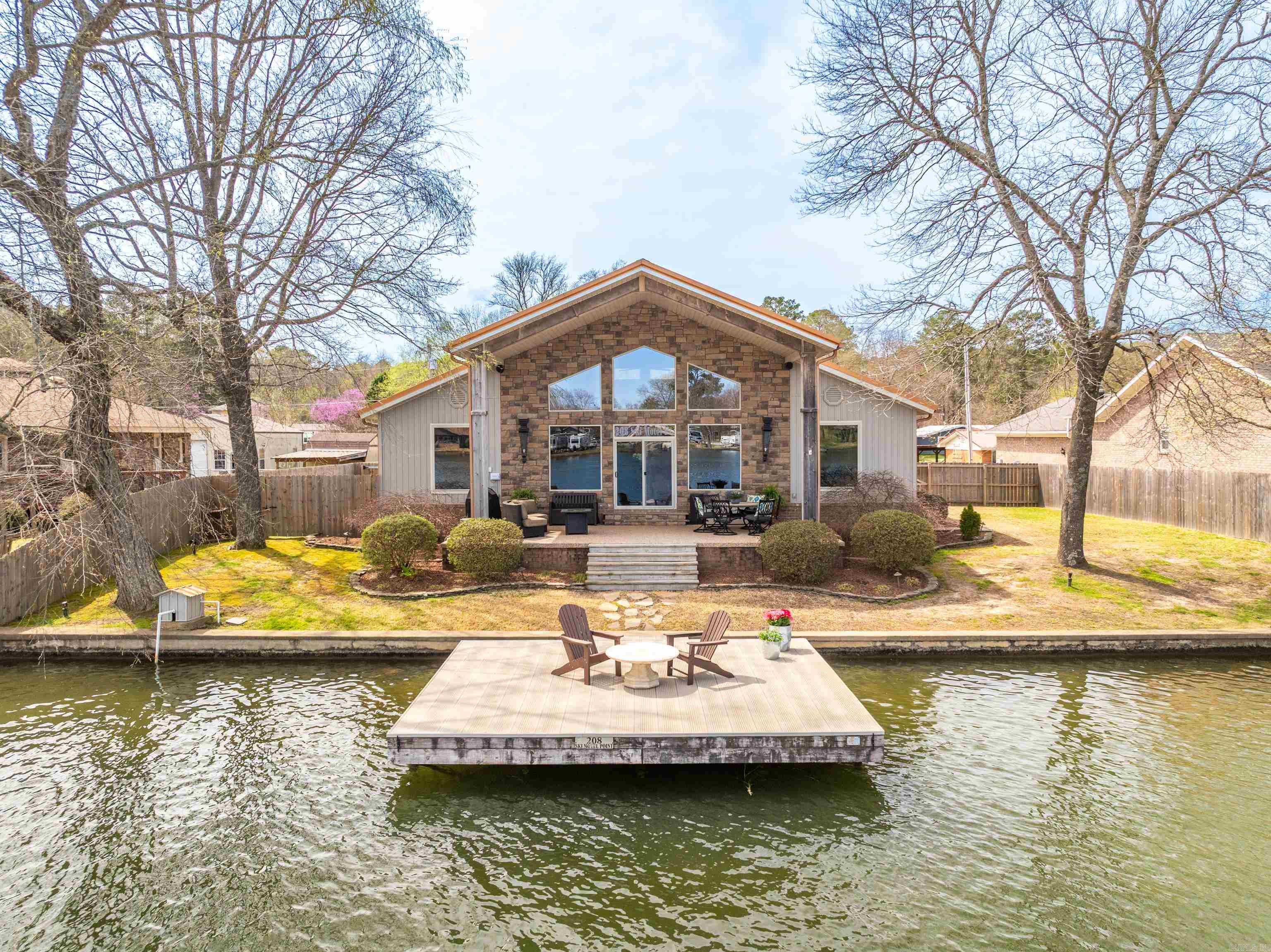 Welcome to the perfect lake retreat, for you and your guests - This beautiful lake house, complete with a charming lake side cottage, offers breathtaking views, private lake access and endless opportunities for relaxation and recreation.  The main house features a gourmet kitchen with high-end appliances, a butler’s pantry for added convenience, and an open-concept living space with soaring ceilings and stunning water views.  A cozy loft provides extra space for an office, lounge, or additional sleeping area.  Step outside to your private swim dock, perfect for sun-soaked afternoons and water adventures.  The cottage provides a private oasis for your guests, or could be used as rental income with 2 bedrooms and 1 bath.  The back deck of the cottage is perfect for entertaining or tossing your fishing line.  The property also features a detached 2 car garage, with plenty of room for vehicles, storage or lake toys.  Behind the garage, you will find the 1 stall boat dock, equipped with a boat lift. Whether you're looking for a dream home, a vacation retreat, or a lucrative investment property, this stunning lake house with a separate guest cottage offers endless possibilities.