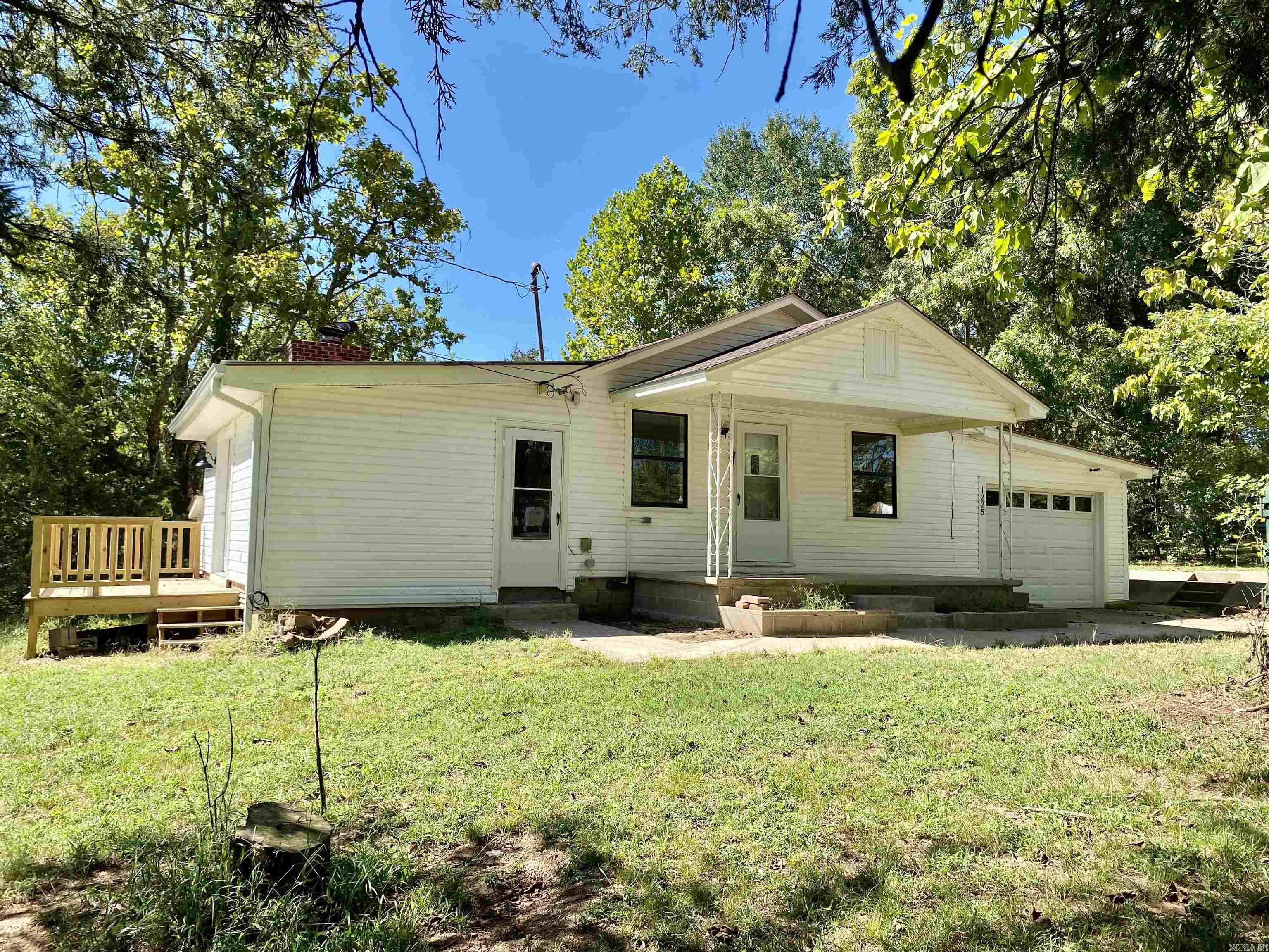 Inviting & charming country style cottage recently updated w/ new flooring, paint, fixtures, baths, & kitchen.  Lovely setting on a 1 acre lot covered in established shade trees with no rear neighbor.  Many outdoor living spaces:  front & rear covered porches & a side sun deck.  Open kitchen/living area w/ attached sunken den w/ rock wood burning FP.  Large kitchen w/ an abundance of cabinetry and a breakfast bar.  Also, offered with a 1 Yr. Home Warranty for buyers peace of mind covering all major appliances & HVAC System.  Attached storm shelter off of den.  Detached shop/garage w/ many storage cubbies.  Ask your agent about $0 down financing options on the lovely residence in Lamar.