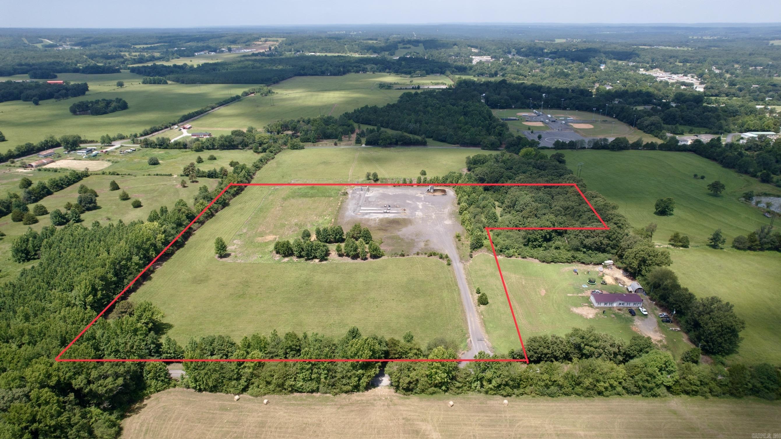 15± Acres for Sale – Maddox Rd., Quitman, Arkansas  Located just beyond the city limits of Quitman, AR on Maddox Rd. Beyond the outskirts of town and minutes from Greers Ferry Lake, this property offers convenience while still providing the peace and privacy of living in the country.  With paved road road frontage, rural water, and electric available, this property is ready for a new build, hobby farm, or future development.  Approximately 4-5 acres along the road frontage provide an excellent area for a homesite or could potentially accommodate multiple homesites, making this an attractive option for both homeowners and investors. The remaining acreage offers plenty of room for recreation or additional privacy.  The property includes an existing natural gas pad but mineral rights do not convey with the sale.  Whether you're looking to build your forever home, establish a weekend getaway near Greers Ferry Lake, or invest in Arkansas land with development potential, this property offers outstanding value in a desirable location.  Contact today for more information or to schedule your private showing!