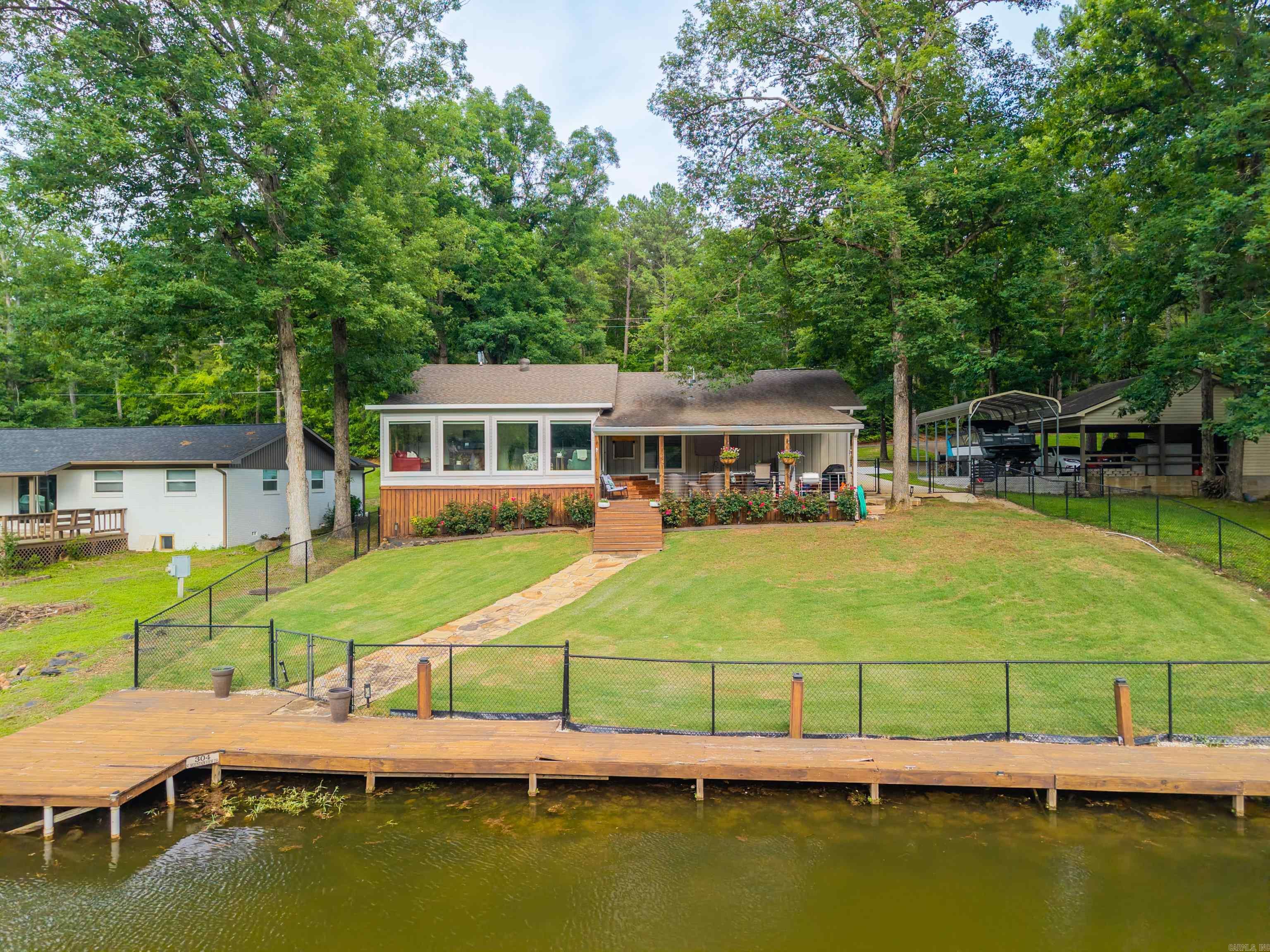 Welcome to your own slice of Lake Hamilton paradise! This charming and beautifully updated 3-bedroom, 2-bath waterfront home offers the perfect combination of modern comfort, stunning lake views, and easy access to one of Hot Springs' most desirable recreational destinations. Whether you're searching for a primary residence, weekend getaway, or an income-producing nightly rental investment, this move-in-ready lake home delivers an exceptional lifestyle and outstanding versatility. Completely remodeled in 2020, the home was thoughtfully redesigned to maximize its lakefront setting with an open-concept floor plan and expansive windows that showcase breathtaking water views from multiple living spaces. Natural light pours throughout the home, creating a bright and inviting atmosphere that perfectly complements the relaxed lake lifestyle. The spacious living area flows seamlessly into the dining and kitchen spaces, making entertaining family and friends effortless while ensuring everyone can enjoy the beautiful scenery. The kitchen serves as the heart of the home with updated finishes, ample cabinetry, and functional workspace designed for everyday living and entertaining.