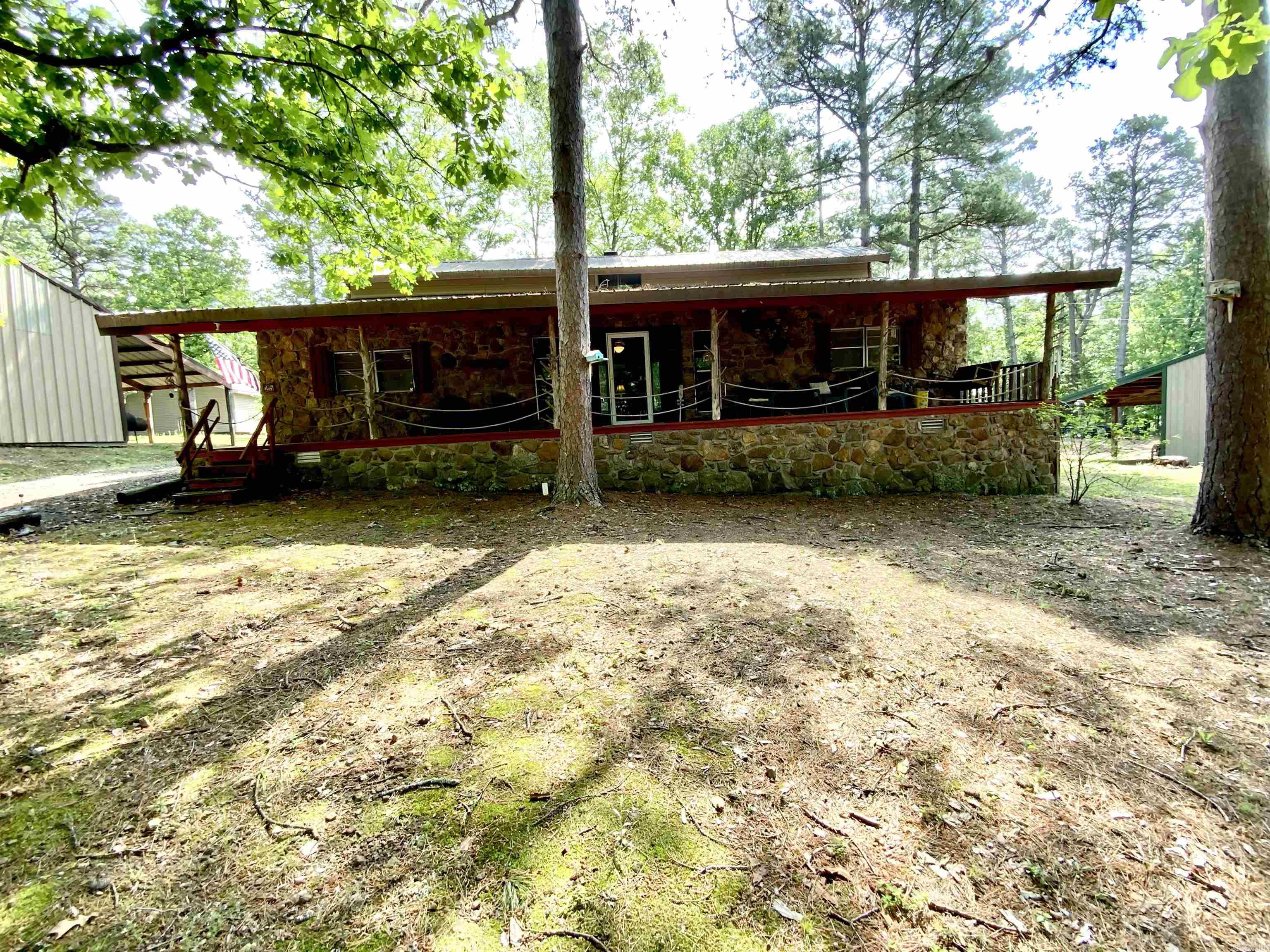 2 Lots for the price of 1!  Arkansas fieldstone lake house - perfect for weekend getaways. Four bedrooms down with a spiral staircase to a large sleeping loft. Great room with stone fireplace converted to propane that could easily be converted back to wood burning. Open kitchen area, two full bathrooms, fully screened back porch and covered front porch. This house sits on Lot 25. The adjacent Lot 23 has the shop of your dreams! Huge 30x50 building has three oversized bays with tall garage doors to accommodate even the tallest pontoon boat and extra room for all of your other toys. There is a large workbench area ready for the handyman/handywoman. It also boasts a 14x50 covered area in back, perfect for storage or BBQ's. ALL FURNISHINGS STAY and you can be on the lake in minutes!