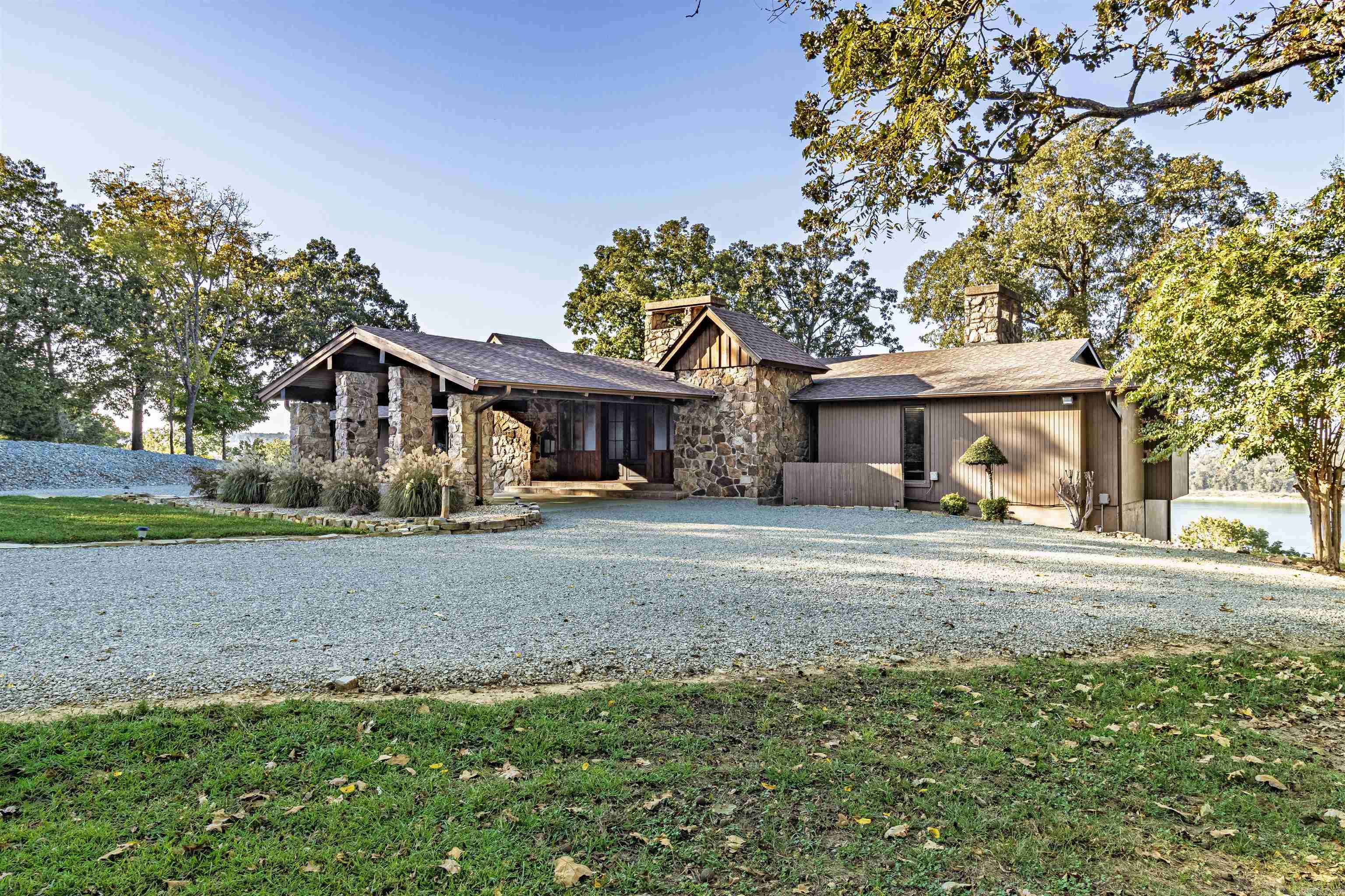 Come feel the warm embrace of this beautifully remodeled and custom-crafted 5684 sq ft lakefront estate on pristine Lake Norfork. Positioned on 3.6 acres with +- 400 feet of lake frontage, this home includes a very rare private boat dock just a short ride away. Step inside to soaring ceilings, custom finishes and panoramic windows showcasing beautiful Lake Norfork.  The heart of the home features three stunning fireplaces-including an impressive native stone wood burning stove anchoring the great room.  The gourmet kitchen offers beautiful lake views, high-end appliances, custom cabinetry, and a layout ideal for gathering with family and friends. A spacious master suite serves as a relaxing retreat with double sided gas log fireplace, cedar lined closet and serene lake views. Multiple guest suites ensure everyone has comfort and privacy. On the lower level you'll find yet another wood stove, game room and full bar designed for fun-filled weekends.  Step outside to expansive decks, screened porch, outdoor kitchen and a cozy Firepit area all with stunning lake views.  Complete remodel and large addition 2019  11 miles to world class trout fishing on White and Norfork Rivers
