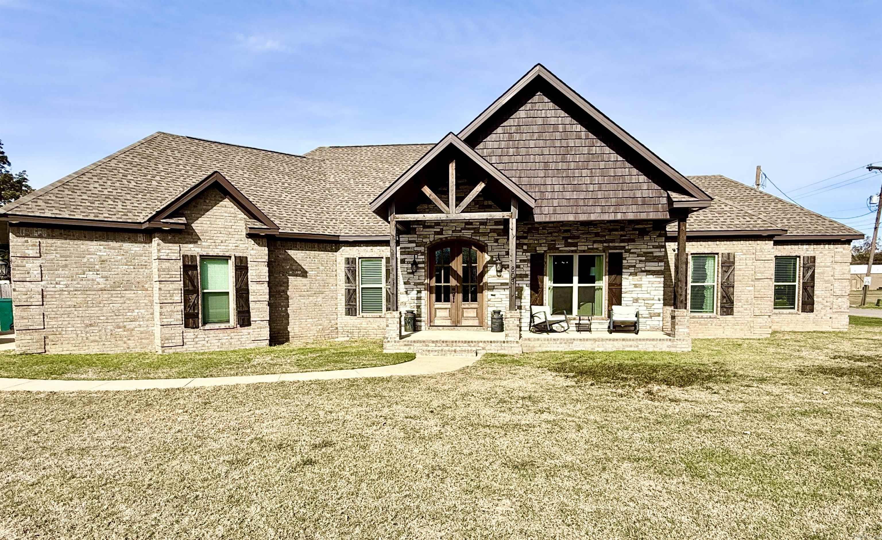 This stunning 4 bed, 2.5 bath home in Manila, AR blends modern comfort with farmhouse charm, featuring an open floor plan, a cozy brick fireplace, granite countertops, stainless appliances, and a spacious kithcen island. The primary suite includes a double vanity, soaking tub, and tiled walk-in shower, while the covered front porch and large yard make it perfect for relaxing or entertaining.