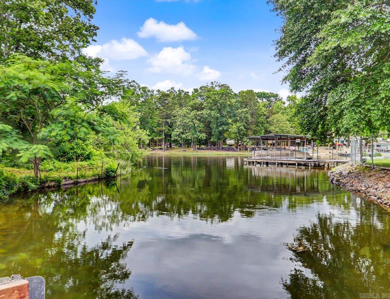 Lakefront Retreat with Private Boat Slip & Resort-Style Setting Lake Hamilton School District  Cute and well-maintained 3-bedroom, 2.5-bath lakefront home offering a peaceful resort-style setting and convenient access to the boat ramp located just behind the property. The home includes a private boat slip, making it ideal for enjoying lake living and water recreation.  Outdoor spaces feature a spacious back deck with both covered and uncovered areas, perfect for relaxing or entertaining while taking in the waterfront setting.  The primary suite includes an extra-large walk-in shower and a spacious walk-in closet, creating a comfortable private retreat. Additional updates include an HVAC mini-split system installed in 2023 for added efficiency and comfort.  All appliances convey, and most furnishings may convey with an acceptable offer, providing added convenience for a primary residence, vacation home, or investment opportunity.  A great opportunity to enjoy relaxed lakefront living in a quiet and scenic setting.