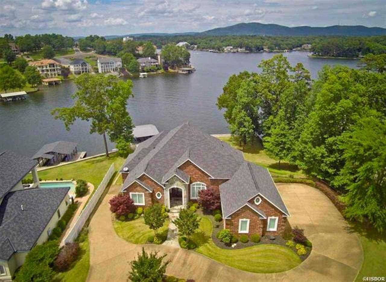Luxury lake living at its finest! Custom detailing throughout will take your breath away. Great Room boast a wall of windows to enjoy your lake views. Formal Dining. Dark wood flooring, custom cabinetry & granite throughout. Living & laundry on main & lower level. Safe room on lower level. Zoned heating & air. Bonus room on upper level could be exercise or playroom. 3 car garage, 2 storage rooms. Covered2 stall boat dock w/lift & separate swim dock.
