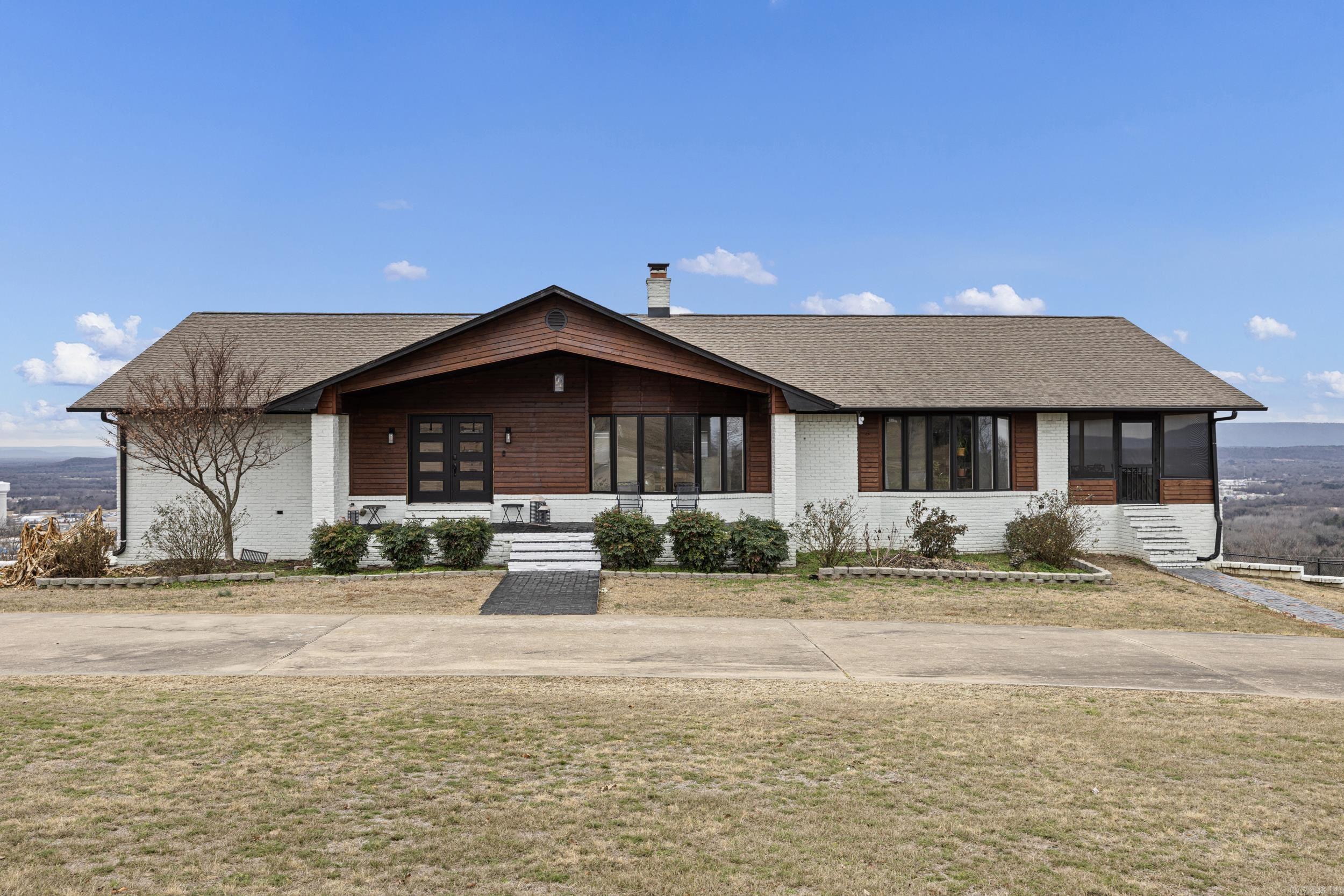 Welcome to your dream home—where comfort, elegance, and modern updates meet breathtaking surroundings on a stunning 2.47-acre setting with complete panoramic views of the River Valley. This newly remodeled 4-bedroom, 3.5-bath home offers a spacious open-concept layout perfect for everyday living and entertaining.  A circle drive and 3-car garage provide impressive curb appeal and added convenience. Inside, you’ll find all-new flooring throughout, fresh paint on walls and cabinets, updated baseboards, and upgraded lighting with can lights.  The large kitchen features modern appliances, ample counter space, and a functional design that flows seamlessly into the living areas. The expansive main living area is anchored by a double-sided fireplace, creating a warm, inviting focal point.  The home also offers two laundry rooms, spacious bedrooms, and a dedicated safe room for added comfort and peace of mind. A newly added downstairs bathroom includes a soaking tub and separate shower with shiplap accents. Barn doors, built-in lockers, upgraded ceilings, and two new water heaters add both style and functionality. This beautifully remodeled home is truly move-in ready and a must-see!