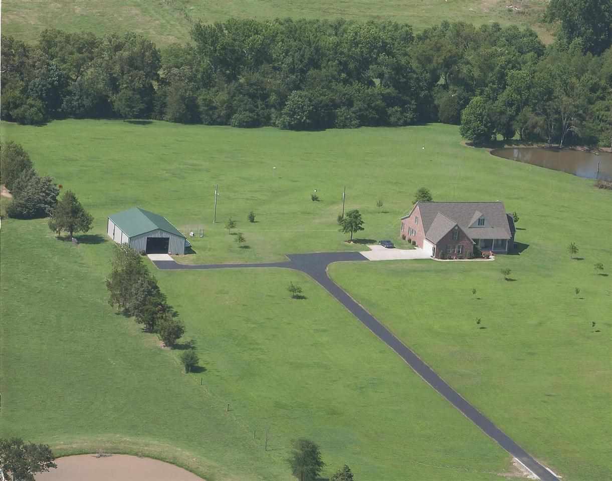 Spectacular property fully fenced.  Host large parties in the 40 x 60 shop with electricity, heat, bath & kitchen.  This amazing home features a 36x9 sunroom, bonus room, formal dining & each bedroom has a private bath.  Behind the stocked, spring fed pond, hidden in the trees is a small private pasture area great for special picnics or getting away from stress. Enter this property through a security gate  & 1000 ft paved driveway & enjoy the beauty of country living.
