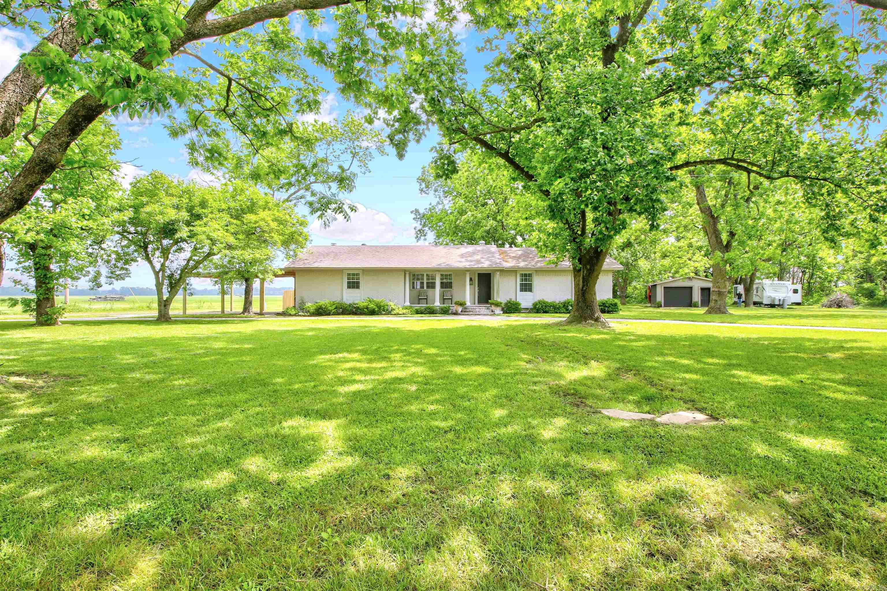 Explore the splendor of this remarkable residence with 12 mature pecan trees adorning the surroundings. Step into the welcoming foyer and feel right at home. The house boasts an appealing open floor plan with exquisite crown molding and wood blinds throughout. Formal living room and separate den with a comforting brick gas fireplace. Kitchen has large island and pantry. The master suite presents a custom tile shower and a charming pedestal sink. Oversized laundry room and spacious bedrooms. Outdoors, a 20 X 20 shop with electric, a new brick patio and new covered back deck is perfect for outdoor gatherings. Renovations include new insulation, a new carport, new flooring, fixtures, faucets and some new paint enrich the property's allure.