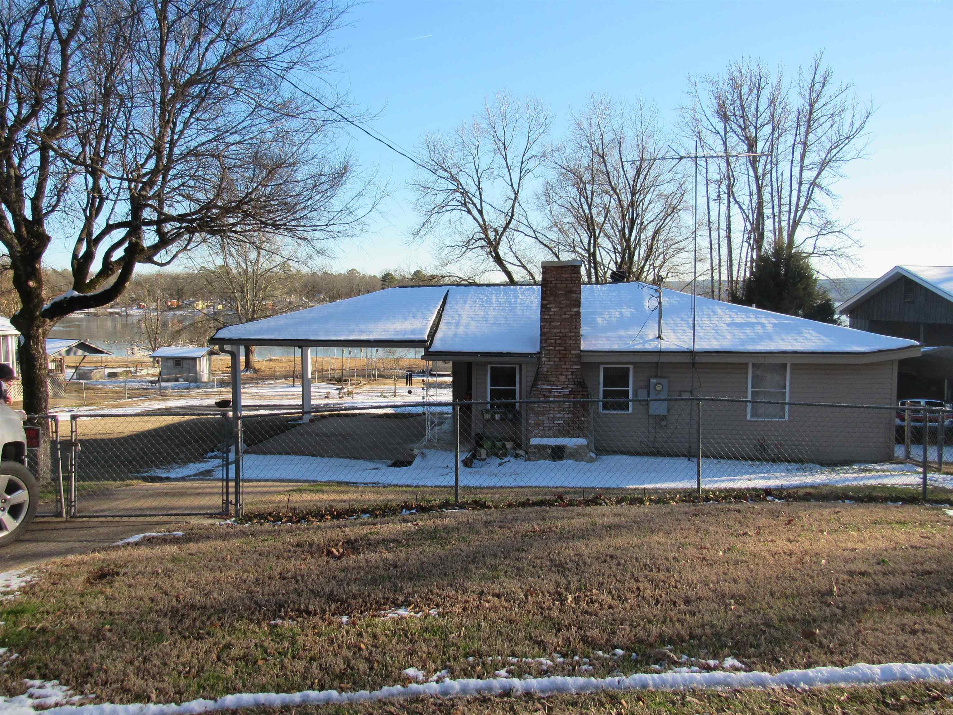 YOU CAN OWN YOUR OWN 100 FEET OF HARRIS BRAKE LAKE ACCESS!  This Lake is famous for prize-winning crappie and catfish.  1300 acres of a fisherman's dream makes this one of the premier spots to fish in all of Arkansas.  This home is in excellent shape and is being SOLD with the furnishings, (including dishes and towels), John Deere riding mower, boat with motor and trailer, two refrigerators, PORTABLE GENERATOR and more!!!  Since 2021 seller has made important improvements like an attic fan, window unit in den, new heat and air unit 2023 ,Wi-Fi thermostat, new 200-amp service brought to house, new electrical box and wiring, built a new shed, rebuilt the sea wall, added crawl space openings to every area of the foundation, fenced the entire half acre lot and so much more.  There is a large enclosure for an RV, a two car detached garage/shop, boat ramp and a covered dock on the water for relaxing and fishing. Home is all electric with a propane gas heater as backup.  Previous seller replaced plumbing and roof. AND one year of Connect First Internet included! This is the PERFECT set up for Airbnb or fishing cabin.  Better hurry if you are interested!