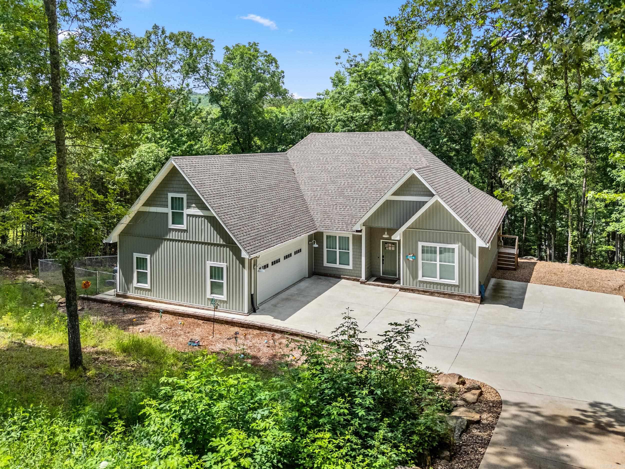 Lakefront living at its finest on Greers Ferry Lake in the beautiful Mystic Isle subdivision. This 4-bedroom, 2.5-bath home offers a perfect blend of modern comfort and retro-inspired style, all set on a cozy, wooded, tree-covered lot just over a half acre with stunning lakefront views and direct access to the water. Inside, you’ll love the inviting living room and bonus room perfect for entertaining or relaxing after a day on the lake. The kitchen is a true standout, featuring a large center island, quartz countertops, custom appliances, abundant cabinetry, a spacious pantry & excellent storage throughout. This home is designed for both function & convenience with a two-car garage plus an additional 16x16 storage area/workshop ideal for lake gear, tools or hobbies. Outside, natural rock landscaping blends beautifully with the wooded surroundings, creating a peaceful & private lakefront setting. Additional highlights include smart-home features: high-speed fiber Wi-Fi, smart thermostat,  garage doors and keypad entry, offering modern efficiency without sacrificing charm. This property delivers the views, access & lifestyle that makes lake living so special.