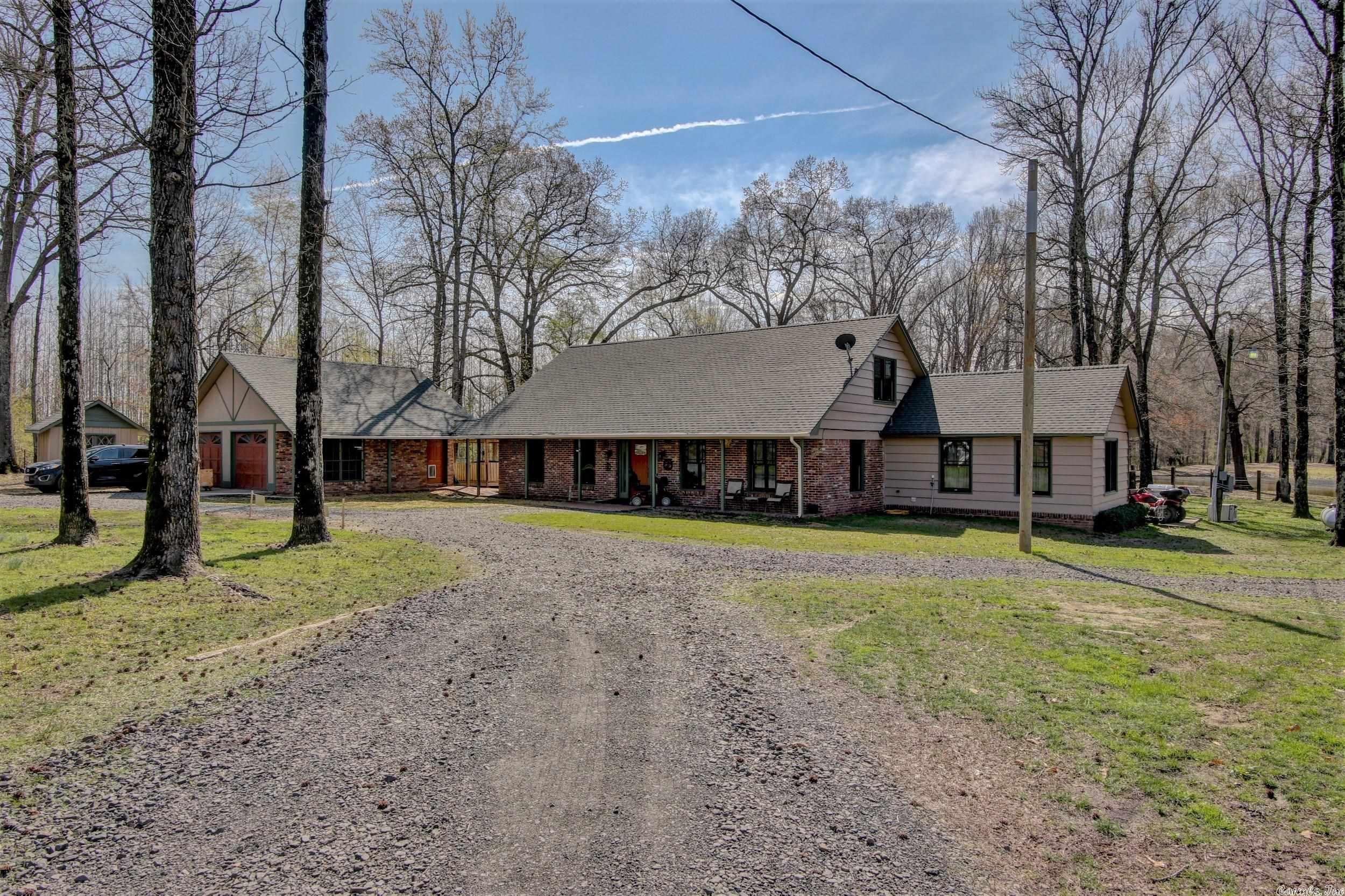 CHECK OUT THE 3D VIRTUAL TOUR! Beautiful rural property just 4 miles from the freeway (exit 19 on 167) and shopping. Best of both worlds. 20 pretty acres that are mostly wooded and fully fenced. Small pond for fishing and a creek. Big barn, fenced and set up nicely for horses or cattle. Big barn and a 6 bay shed for parking tractors, mowers, etc. plus a 2 car detached garage. There are three living areas in the home with 3 fireplaces. Den could be a 4th BR. Also a 292 SF sunroom with a minisplit HVAC unit that is not included in square footage. There is a whole house Cummins generator and propane tank added in 2022 will convey. The master bedroom and bath have been modified to be handicap accessible. Home is on public water but has a working well to water lawn, garden etc. There is an electric gate at the highway entrance. Plenty of wildlife to enjoy. There is a berm made with cross ties so you can target shoot from your deck. Several out building for storage. A small fenced in area for your dogs. There is a loft area in the barn that would be great for overnight parties for the kiddos. There is so much on the property it is hard to cover everything. Come see it for yourself!!!!!!