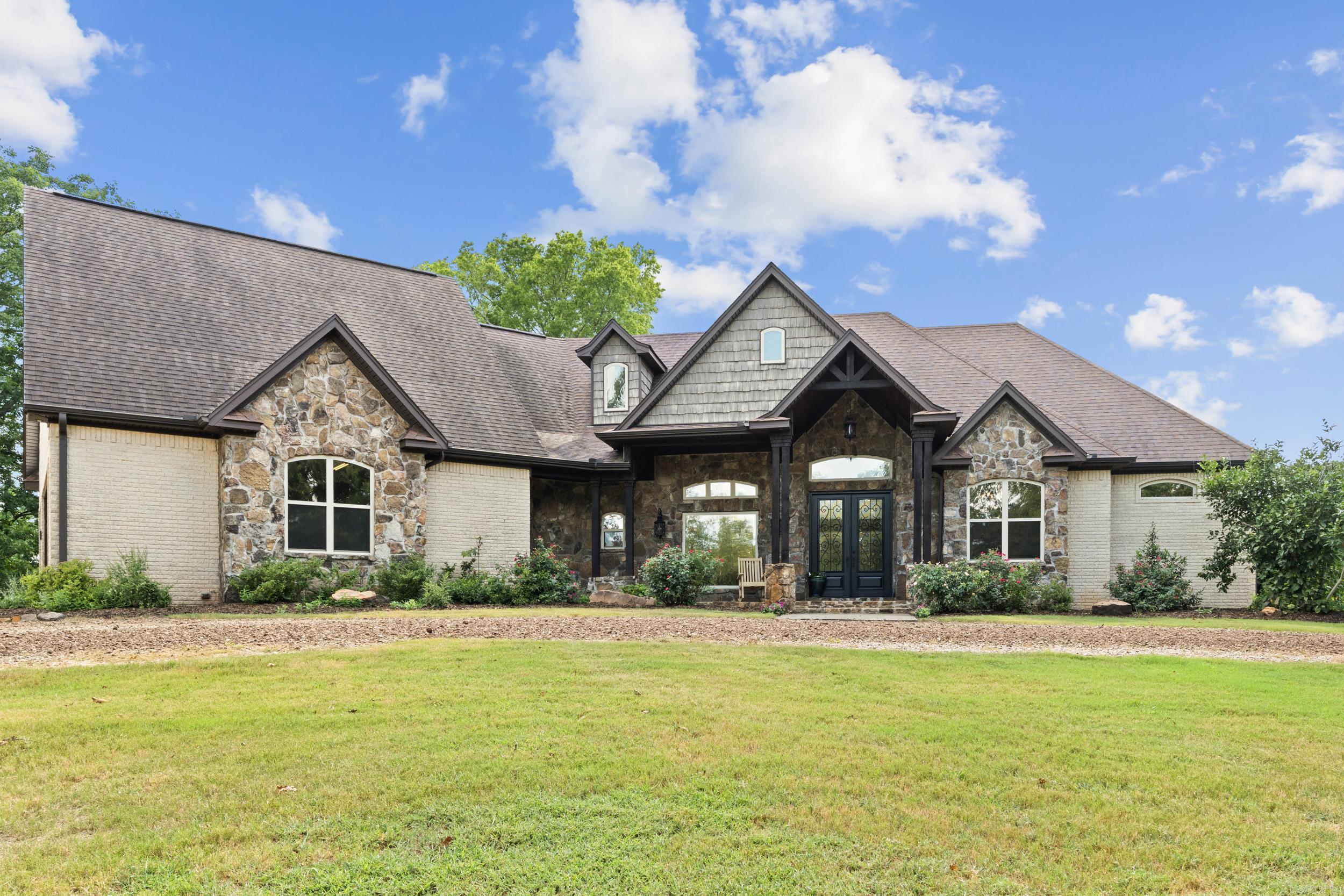 Escape to the perfect blend of country living and city convenience! This beautiful home sits on 10 scenic areas just outside city limits, offering privacy, space and peaceful surroundings without sacrificing easy access to shopping, dining, schools and other amenities. 20-foot rock fireplace with gas logs, wood floors, Cathedral, pine-stained columns and beams throughout the entire home. Gourmet kitchen with 3-inch granite on all countertops and backsplash. 48-inch Thermador range, built in thermador vent, Jenn Air refrigerator to convey. Main bedroom has wet bar with double under counter beverage refrigerator hidden behind double doors. Main bath has Travertine tile throughout, travertine shower with 2 spray heads. Three Rheem HVAC. Culligan water (rented softeners only) $100 month to maintain. See Docs for more information.