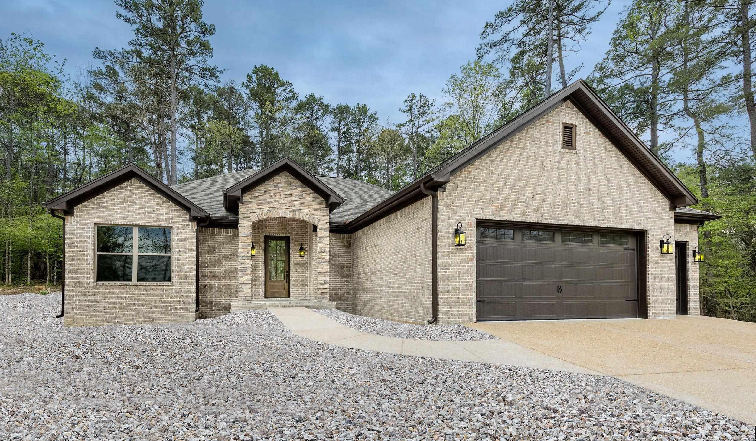 Introducing a newly constructed, MOVE IN READY home featuring an expansive three-car garage. The exterior boasts a classic all brick design complemented by elegant stone accents. Inside, you will find luxurious finishes including spacious walk-in closets, an oversized pantry, and stunning quartz countertops. It's conveniently located just across the street from picturesque Lake Balboa, nestled within the charming community of Hot Springs Village. Constructed by premier builder, McMillan Homes, this residence exemplifies exceptional craftsmanship and quality design. A one year Builder Warranty provides peace of mind for the new homeowner. Additionally, the seller is offering a $2000 concession towards  POA water buy-in, enhancing the value of this opportunity. Landscaping is included, taxes based on vacant lot only.