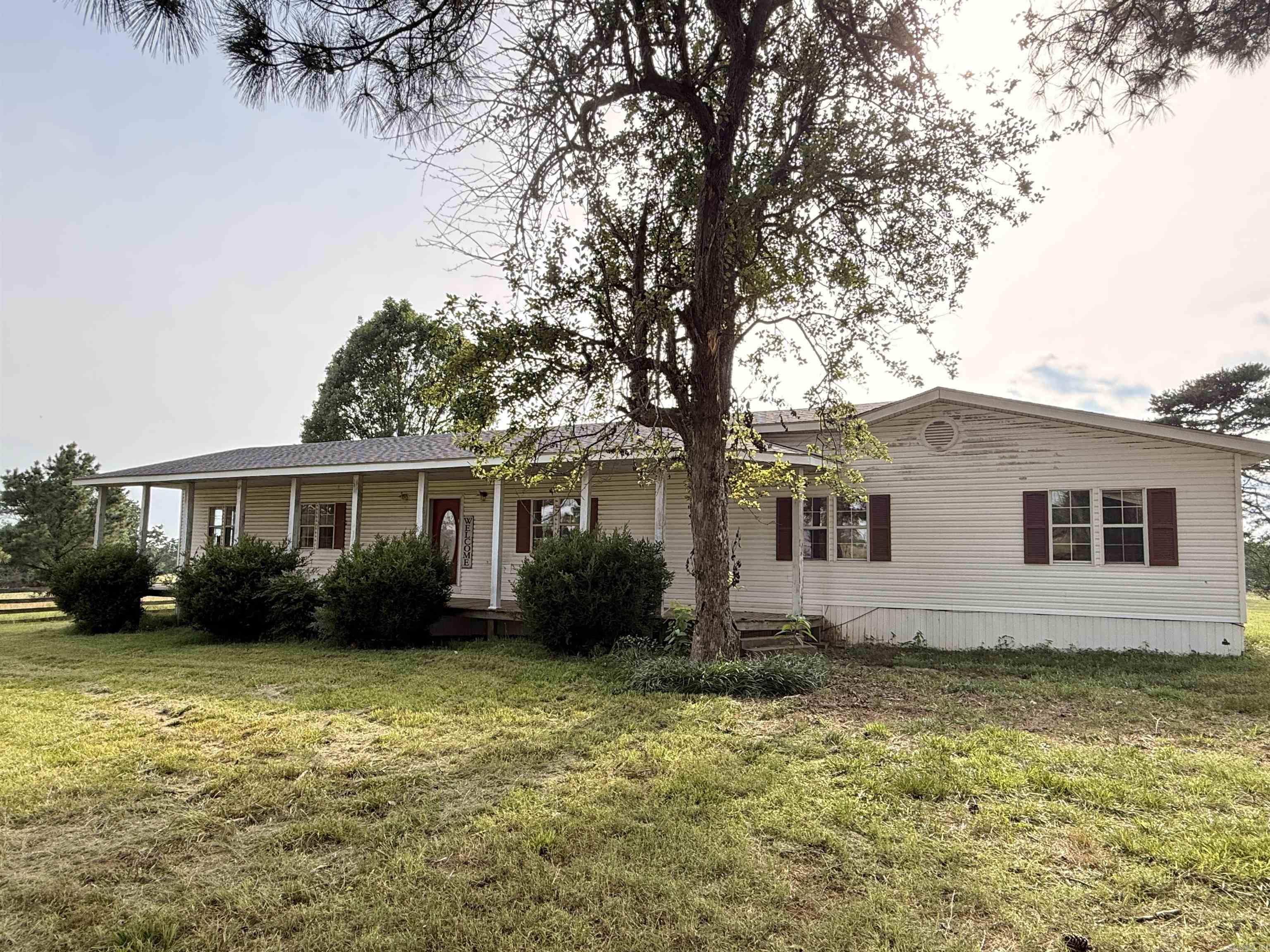 Situated on 3.67 fenced acres near Heber Springs, this property is set up for horses, livestock, equipment storage, or workshop use. The 1,928 SqFt home includes 4 bedrooms, 2 bathrooms, an open kitchen and living area, a pine wood accent wall, wood stove with brick hearth, storm shelter, and a new roof. Positioned on top of a hill, the home overlooks rolling pasture and offers views across the property, with large pines, shade trees, and no close neighbors. The insulated 30x60 barn sits on a slab foundation and includes drive-through bay doors, water, electricity, a wash stall with drainage, 4 large horse stalls, a round pen, and a gated entrance. Fenced pastures, separate electric service for the barn and house, public water, and paved road access add to the property’s functionality. The home will benefit from repairs and updates and is being sold as-is. The property’s horse facilities, rolling pasture, and hilltop setting offer a solid starting point for buyers looking to restore and improve the existing home. CASH only offers.