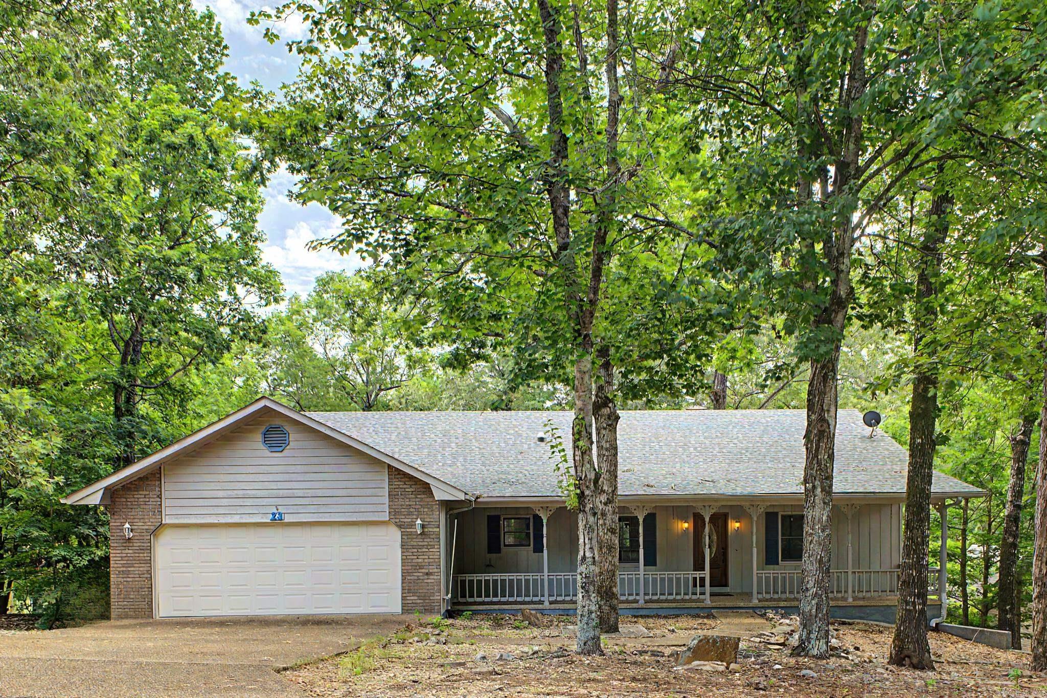 Situated directly on the Cortez Golf Course, this Hot Springs Village home is ready to be your own personal retreat or golf getaway haven. The property features expansive decks and a comfortable front porch that maximize outdoor living space overlooking the course. Many mature trees offer ample shade Inside, the main level centers around a large kitchen with exceptional storage capacity. A split floor plan ensures privacy, separating the primary suite from two nicely sized guest bedrooms. An oversized garage easily accommodates vehicles and it includes a dedicated heated and cooled workshop. The lower level offers incredible flexibility with a private separate entry apartment featuring two rooms and a second workshop, ideal for hosting visiting friends and family or a multigenerational set up with separate living. Practical additions include a fenced area for pets and a whole house generator and a 500 gallon buried propane a tank that conveys with the property.  Agents see remarks.