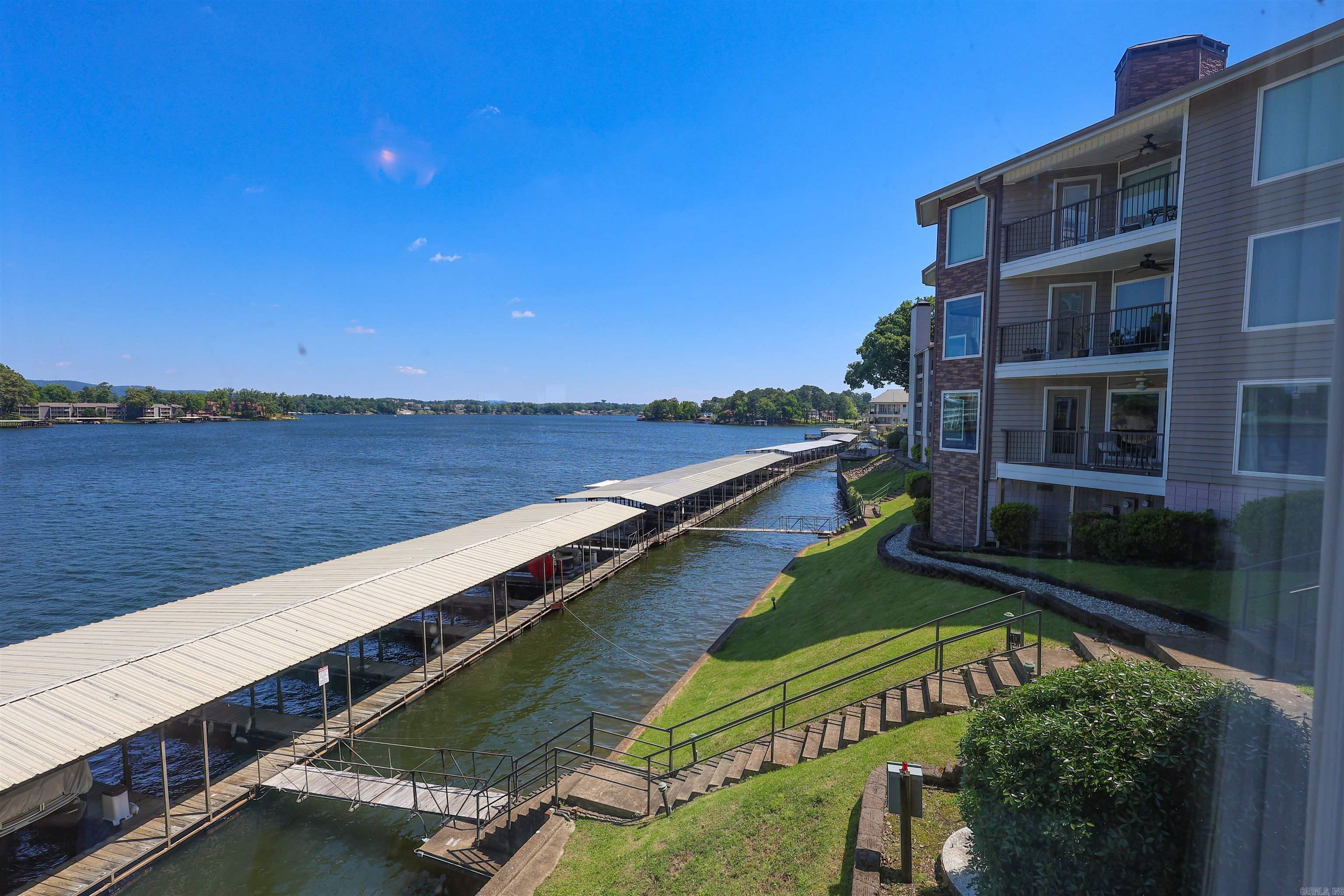 Experience lake living on the main channel of Lake Hamilton in the Stoneridge community. This condo offers scenic views of the water, the bridge, and vibrant sunsets from a well-positioned setting. The interior features an open, bright layout designed for comfortable everyday living or weekend use. Step outside to the deck with convenient access to a designated boat slip and lift.  This property presents flexible use options, whether for full-time living, a second home, or potential rental income. Located near dining, shopping, and Oaklawn, it provides easy access to local attractions and amenities. Seller is owner/ agent.