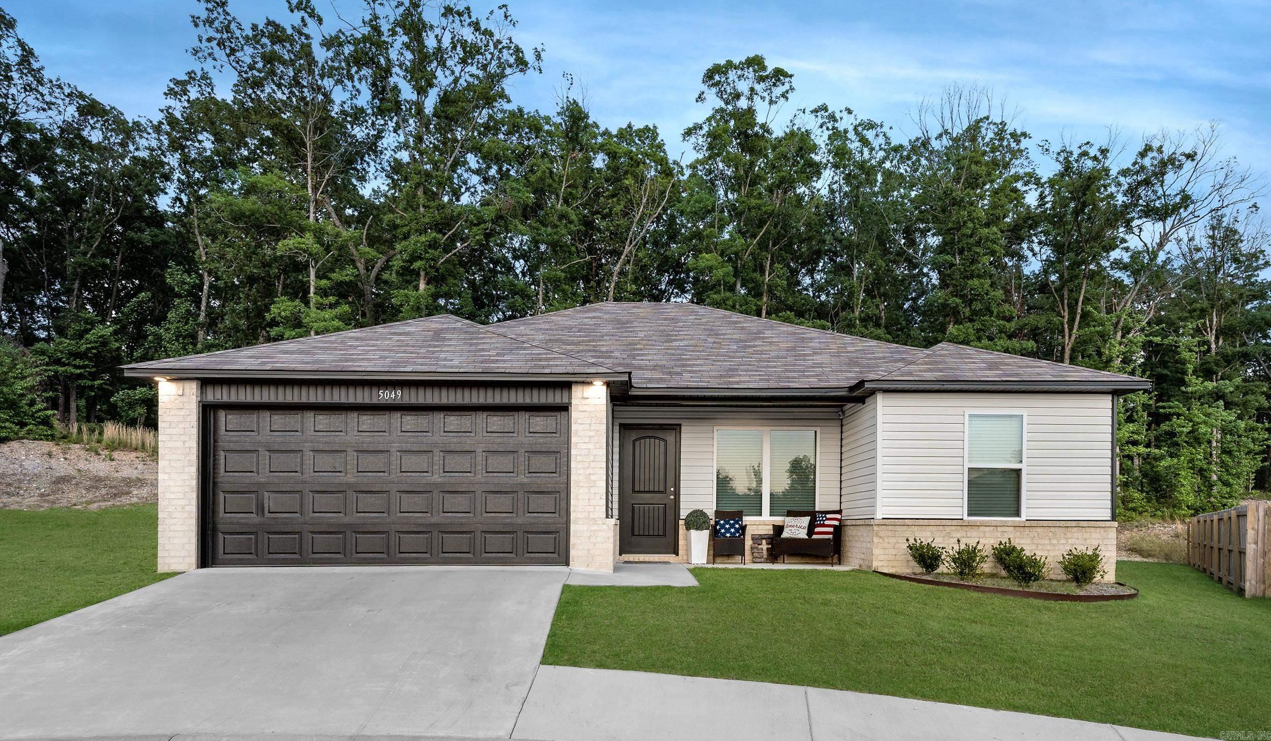 Welcome to this beautifully maintained three-bedroom, two-bath home in the desirable Hilldale Crossing subdivision. Only two years old, this inviting home offers modern comfort, thoughtful design, and a peaceful setting backing to a wooded area for added privacy. Eligible for RD financing.  Enjoy relaxing mornings on the charming front porch before stepping inside to an open-concept floor plan designed for comfortable everyday living and entertaining. The eat-in kitchen provides a functional and welcoming space for gathering with family and friends.  The spacious primary suite features a private bath and an oversized walk-in closet. Outdoors, enjoy the serene backyard setting with wooded views that create a quiet retreat right at home.