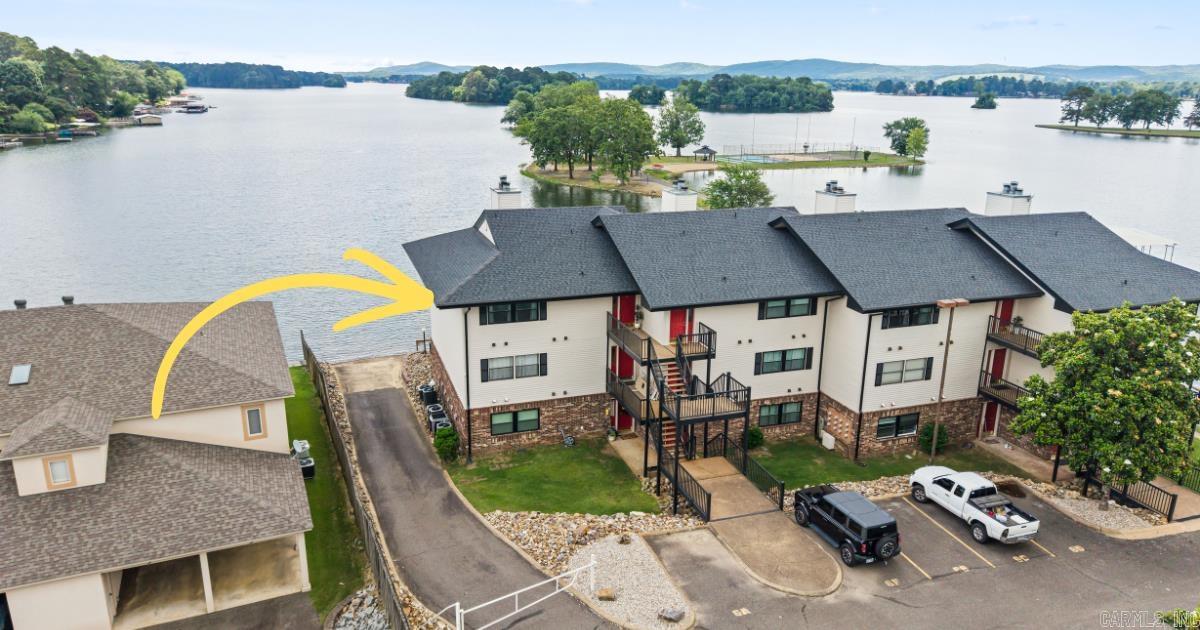 Truly one of the best Lake Hamilton views! Water and mountain views abound.  A stroll down Emerald Isle's private peninsula (for residents only) takes you to to the private beach, mini golf, tennis court, sand volleyball, and basketball court. The swimming pool and hot tub (located just outside the clubhouse) were recently renovated and have a dog run and grilling area for even more recreation and entertainment. At just $250/month, all of these amenities come with one of the lowest POA fees on Lake Hamilton. POA now allowing short-term rentals! Both bedrooms have en suite bathroom access. Primary has it's own patio door to open wide and let the sights and sounds of the lake in. Fully renovated with luxurious thoughtful touches, fully furnished, and fully ready for you to move in! Make 2026 the year you chose to embrace all that Lake Hamilton has to offer. Schedule your showing today!