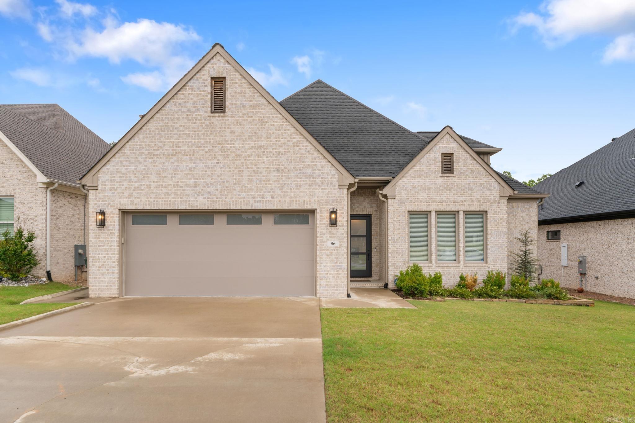 This home qualifies for zero down and no PMI financing through Regions Bank, W.A.C. — making 86 Copper Circle one of the most accessible listings in Copper Run. The floor plan puts the primary suite and a second bedroom — ideal as a guest room or home office — on the main level, with two additional bedrooms and a full bath upstairs. The main-level guest bedroom has its own ensuite bath and walk-in closet. Ten-foot ceilings and an open-concept living area keep the main floor feeling spacious and connected. The kitchen is anchored by a gas range, convection wall oven, quartz countertops throughout. The primary suite is a genuine retreat: double vanities, a soaking tub, an oversized frameless glass shower, and a walk-in closet with built-in storage throughout. The full-size laundry room includes cabinet storage and a built-in hall tree for shoes and coats. Out back, a covered patio opens to a fully fenced yard with a doggy door — and the home backs to greenspace for added privacy. The neighborhood is flat and walkable. Engineered for efficiency: tankless water heater and high-efficiency HVAC. All brick. Located in Copper Run, west Little Rock, minutes from Chenal Pkwy. Agent Remarks!