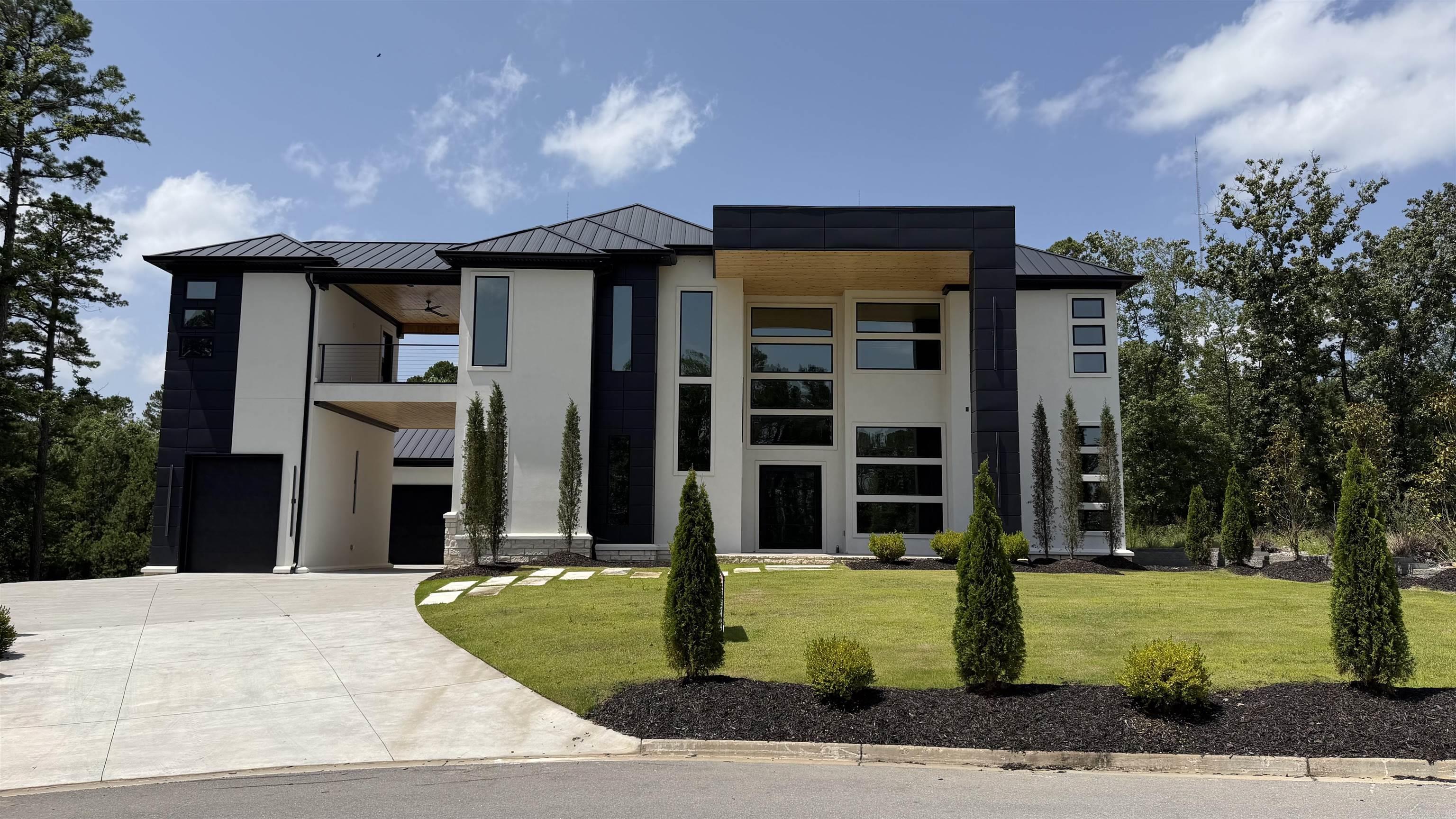Stunning modern luxury at 84 Orle in highly desirable West Little Rock. This exceptional residence showcases dramatic floor-to-ceiling windows, soaring ceilings, and an open-concept layout filled with natural light. Refined finishes include luxury designer lighting, exotic stone accents, a handcrafted chandelier, and distinctive flooring throughout. All windows have 40% reflective tint with a lifetime warranty.  Built for entertaining, the home features dual kitchens and pantries, sleek appliances, high-end finishes, and a striking waterfall island. Enjoy premium lifestyle amenities including a private fitness room with wet bar, custom theater, and expansive balconies offering serene views. Complete with multi-car garages, elegant courtyard entry, and bespoke details at every turn, this is a rare opportunity in one of Little Rock’s most sought-after areas.
