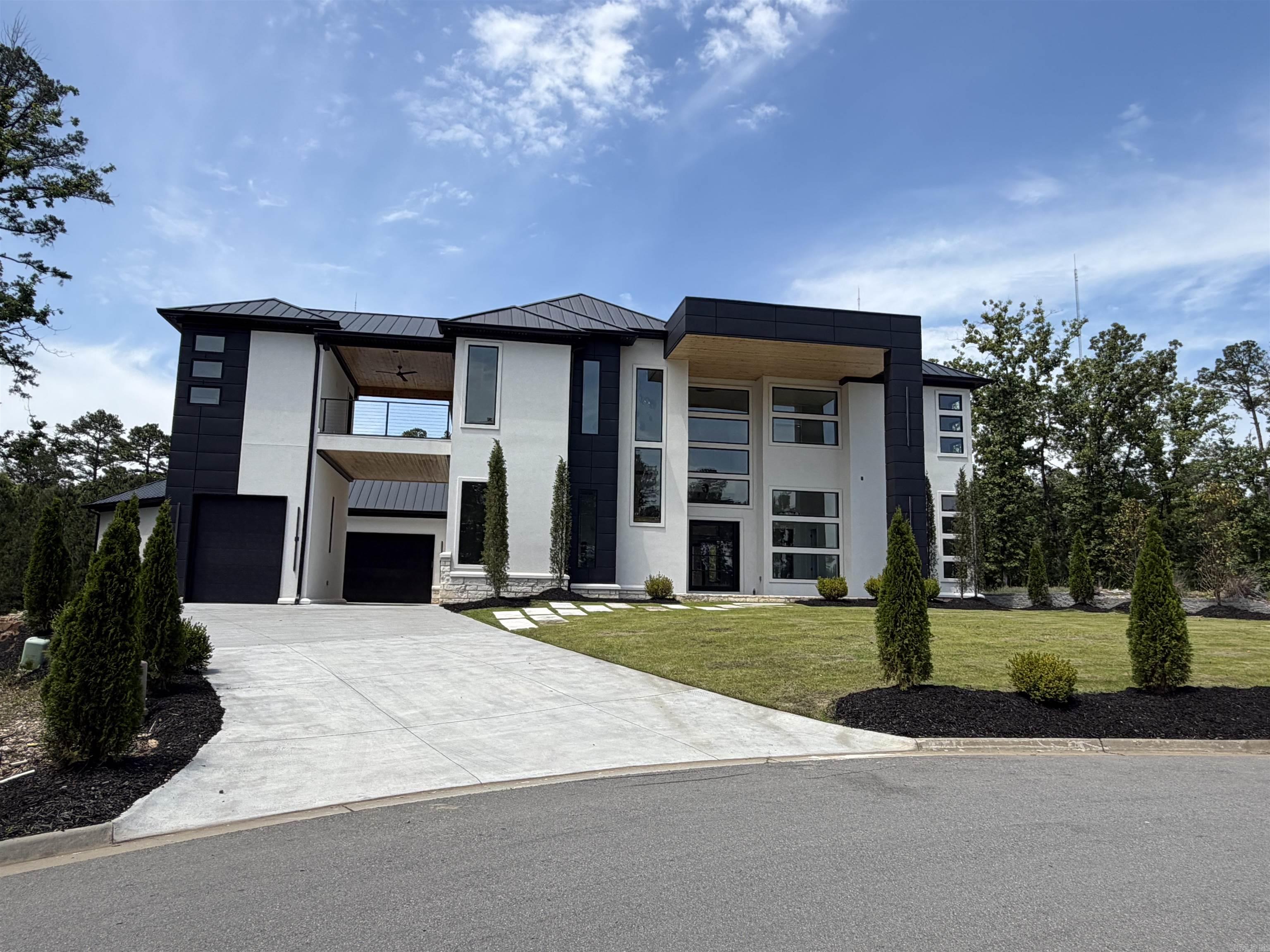 Stunning modern luxury at 84 Orle in highly desirable West Little Rock. This exceptional residence showcases dramatic floor-to-ceiling windows, soaring ceilings, and an open-concept layout filled with natural light. Refined finishes include luxury designer lighting, exotic stone accents, a handcrafted chandelier, and distinctive flooring throughout.   Built for entertaining, the home features dual kitchens and pantries, sleek appliances, high-end finishes, and a striking waterfall island. Enjoy premium lifestyle amenities including a private fitness room with wet bar, custom theater, and expansive balconies offering serene views. Complete with multi-car garages, elegant courtyard entry, and bespoke details at every turn, this is a rare opportunity in one of Little Rock’s most sought-after areas.