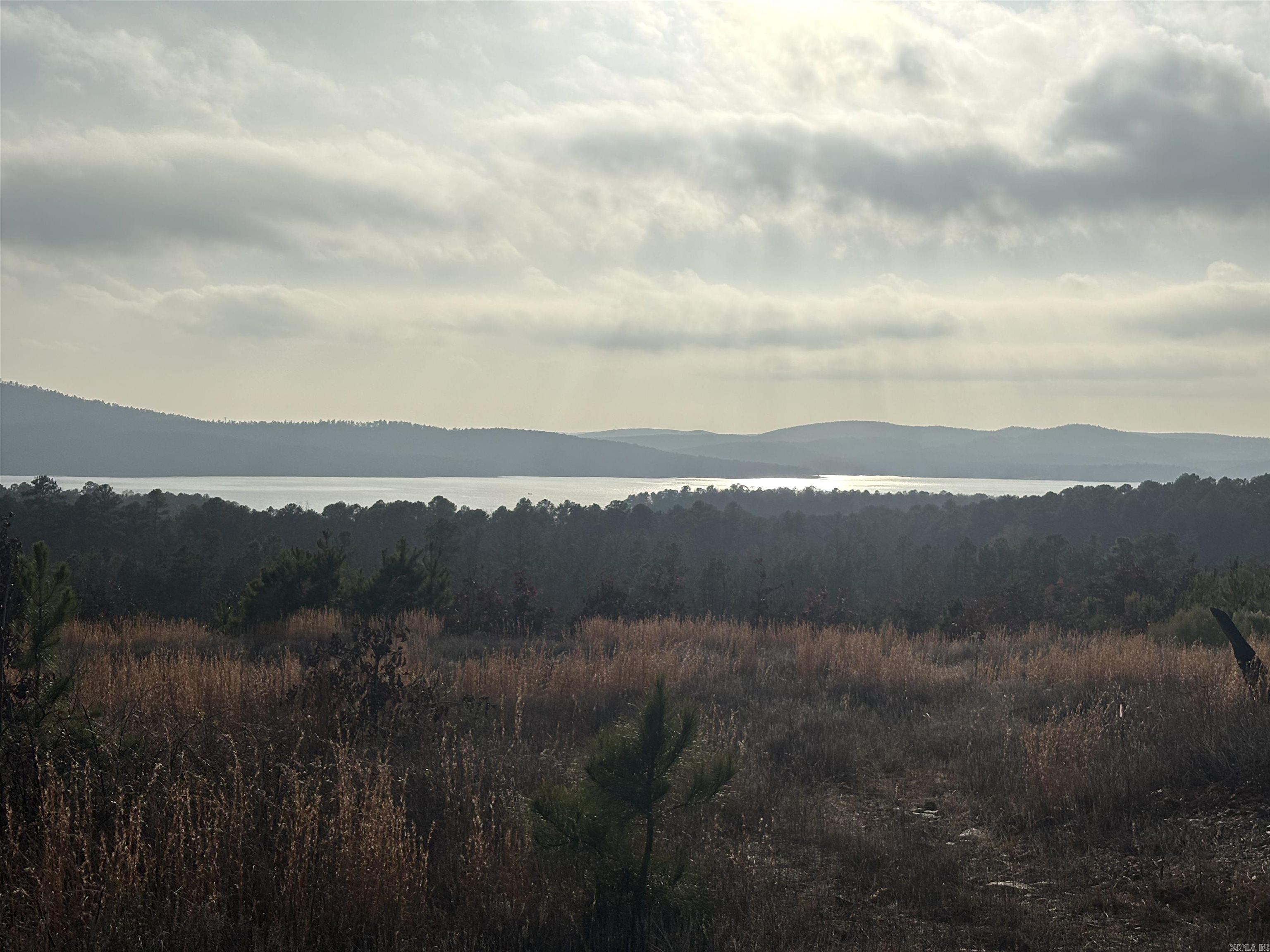 This lot has an incredible view overlooking Lake Maumelle, The Alotian Golf Club, and the Western Mountain Range! This lot is almost 200 feet wide offering ample privacy on either side. To have this view with a flat backyard and space to build your dream house on is incredibly rare! The gated Waterview Estates offers amenities such as pickleball courts, tennis court, basketball courts, and a soccer and football field. You will also discover miles of nature walking trails and enjoy a community bonfire area at your leisure!