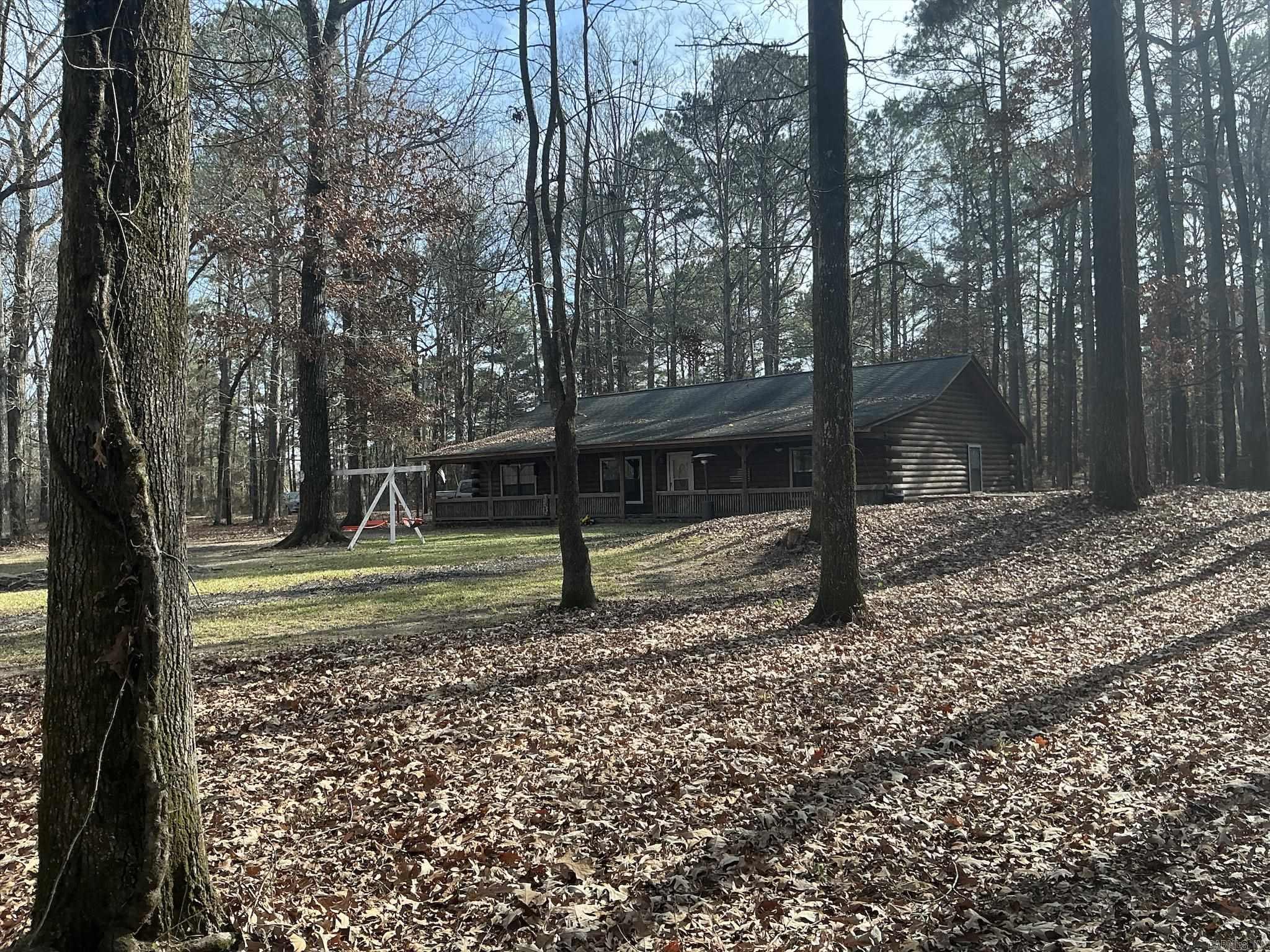 Beautiful custom-built log cabin on a 9.44 acres. Relax on the full-length porch with ceramic tile flooring and enjoy the natural landscaping of this hidden cabin. Open living, dining and kitchen with walls and ceiling lined in tongue and groove Blue Ponderosa Pine. The large living room is open to dining/kitchen.  Ceramic tile with fireboard along living room wall for safe placement of wood stove if desired, Custom kitchen with island breakfast bar, new dishwasher,  fold out pantry, and stove.  Large master bedroom with double walk-in closets, Master bathroom has clawfoot tub, walk-in shower, own 40 gallon hot water heater servicing only the master bathroom! 2nd Hot water heater for other part of house.Other two bedrooms also have walk-in closets and hall  bath has shower over bathtub.  All interior doorways measure 36".  Matching 24x40 shop sits on property and seller has made a bonus room on one end of the shop.  Property has fenced in front yard and first part of land is a cleared pasture, no fence.  Lots of trees, long driveway leading to property for privacy.  Central Unit one year old.  This is one house you must see.