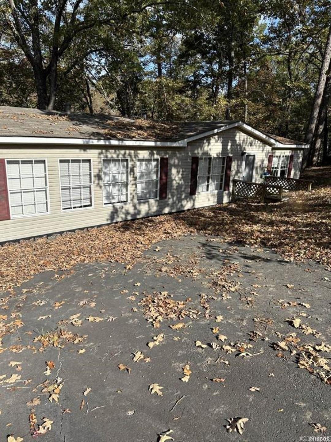 3 BR 2 BA Manufactured home on wooded lot with water frontage and dock on beautiful Lake Catherine. A Boat launch is right around the corner. Home has primary suite with huge walk in closet separated from the other two bedrooms. Large pantry, laundry room and kitchen with island. Nice blacktop driveway with covered parking and 30x24 Metal Workshop. Home has new washer, water heater, garbage disposal and dishwasher. Most were never used. All furnishings and furniture in home and workshop will come with property and will be sold as is.