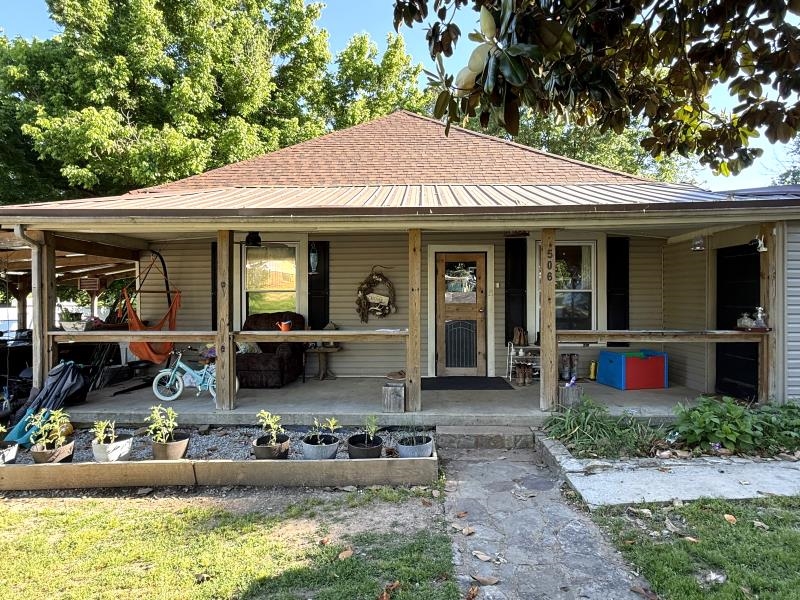 4 bedroom, 2 full bath home on approximately a half acre! Some of the key features include: new windows in 2008, new roof in 2022, 200 amp service upgraded in 2024, a custom built smokehouse, chicken coup, and a 20X20 attached workshop on a slab with concrete floors. The home features a cute, country-style front porch, an attached carport, a doggy door that leads out to a fenced area, large living area, a gas log fireplace, separate dining room (but right off of the kitchen), central heat and air, plus mini splits in the newest room additions. The decor is absolutely adorable throughout, and makes you feel right at home the minute you open the door.  There is also a storm cellar for those stormy days and nights in the spring! Lots to love about this home and property!