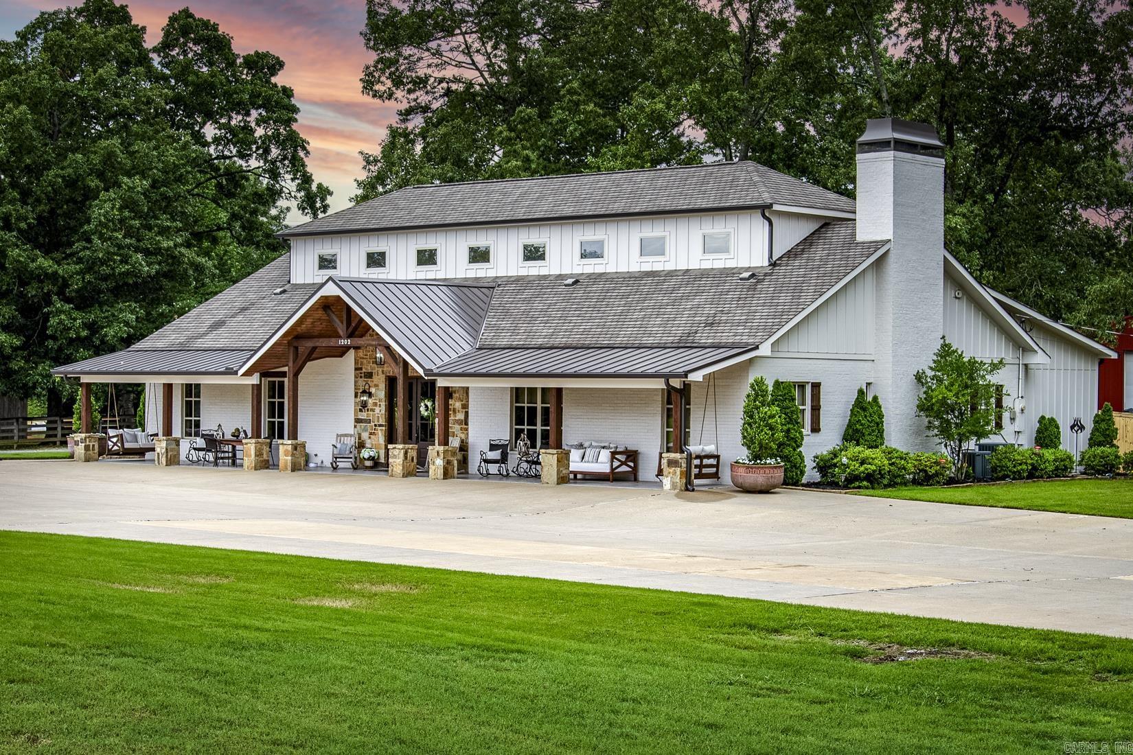 An outdoorsy dream 2 house estate tucked away just outside of West Little Rock. 4 bedroom, 3.5 bathroom beautifully designed barndominium on 13 acres with matching modern guest home. The main property features both a master suite and guest suite on the first level, open living space, formal dining, office/bonus room, creative flow space and oodles of smart storage. Upstairs two generously sized bedrooms both with walk-in closets share a third full bathroom. Front acreage is cleared and fenced for hobby farming or equestrian use, great shade trees throughout, and further past the homes lies a stocked pond with lighted pavilion island which make summer evenings dreamy and full of fun! The 1800 sq. ft. shop with 25 ft. bays can house all your favorite outdoor equipment. Guest home has living area, master suite, full service kitchen, and upstairs loft which can fit 3 twin beds! Attention given to all the details make this a diamond listing, truly one of a kind. Received multiple offers when sold previously. Agents see remarks.