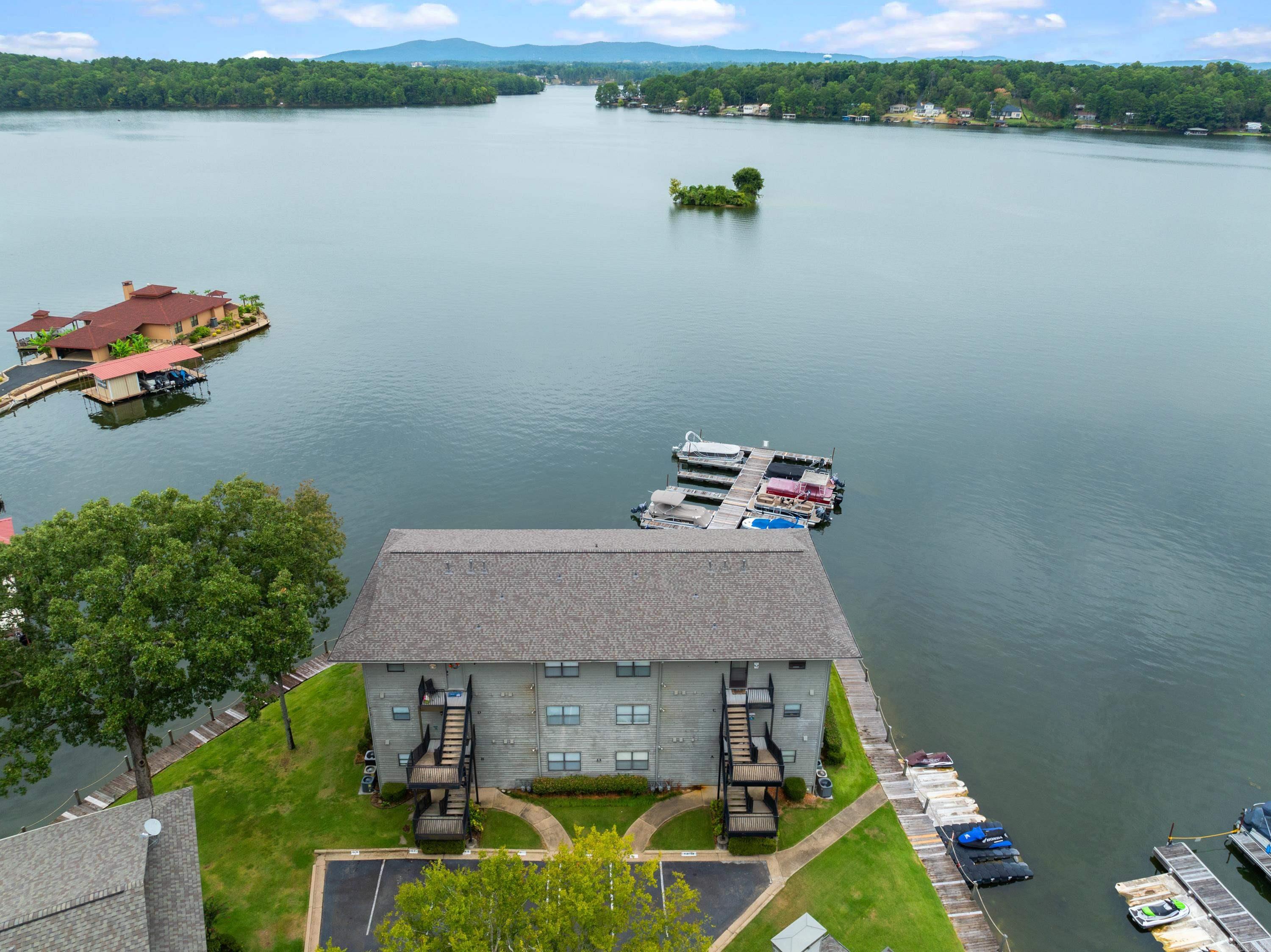 Panoramic views of Lake Hamilton allow you to enjoy sunrise AND sunset on the wrap around deck. 1360 sq ft make this 2nd floor 2 bedroom fully furnished condo larger than most other units in Farr Shores. Enjoy easy entertaining from the large kitchen that is open to the freshly painted living room. The primary bedroom has a picture window and access to the deck plus a large walk-in closet a huge en-suite bathroom.  The 2nd bedroom is large enough for a queen bed plus a bunk. Your boat slip is just steps away and there is a PWC dock as well with this unit. Farr Shores allows nightly rentals and has a pool, tennis courts and private boat ramp. Easy drive to Garvan Gardens, Oaklawn, Magic Springs, Bathhouse Row, National Park trails and Mountain Tower