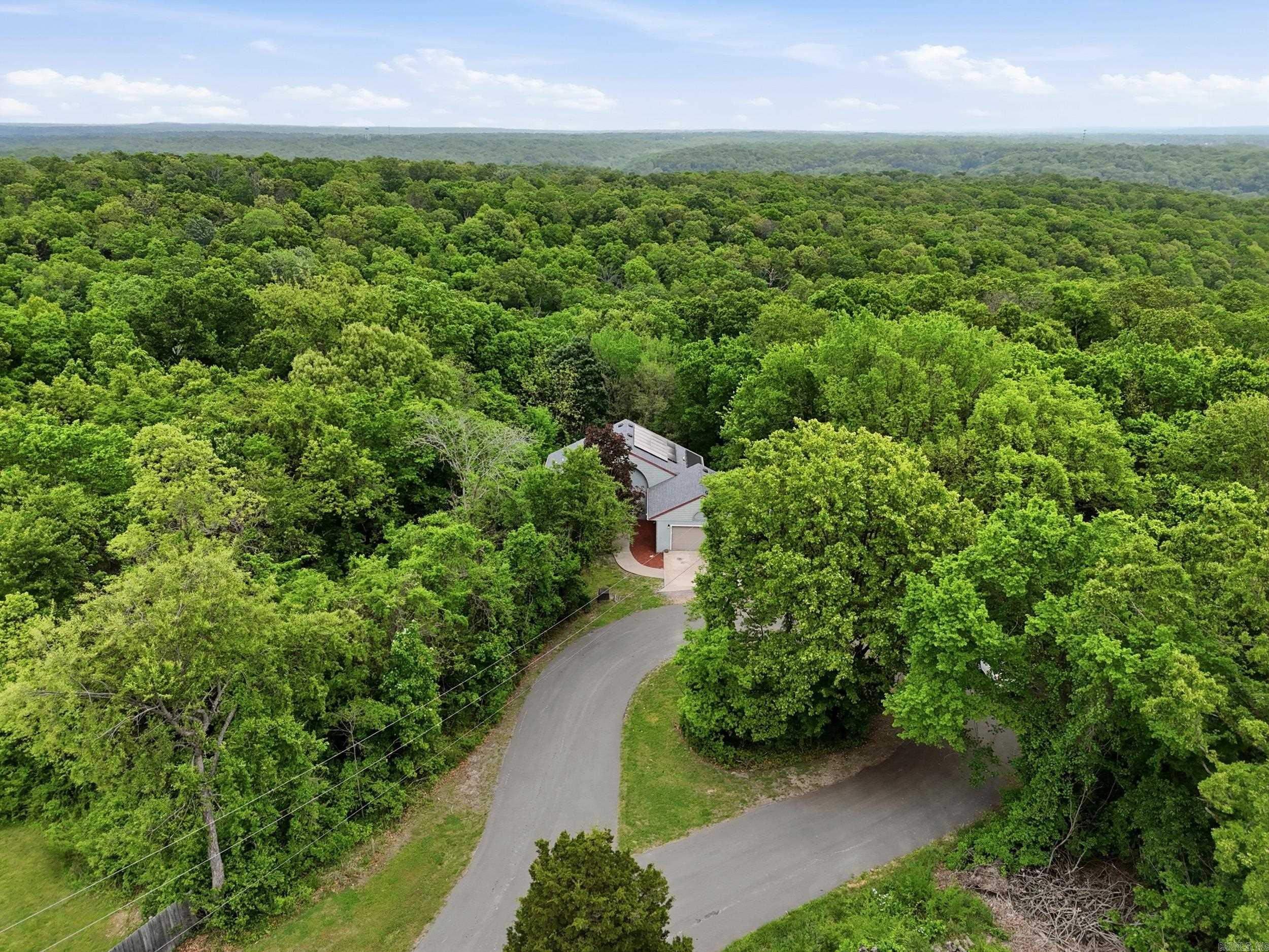 Prime Bella Vista Location! Just 12 minutes to Walmart Home Office, located at the end of a quiet street, surrounded by acres of woods and direct MTB trail access, this spacious home offers 4 bedrooms and 2.5 baths, plus a family room, office, and an impressive oversized workshop. The living room showcases soaring ceilings and abundant natural light from expansive windows. A large second laundry room on the main level provides excellent flexibility and could easily serve as a craft room or additional indoor storage. Enjoy peaceful views of the woods from the double rear decks. Tucked away on a private cul-de-sac lot, this home offers exceptional privacy and abundant wildlife. The kitchen features generous counter space, a breakfast bar, pantry, pull-out shelving, and a built-in desk area. The lower-level workshop, located beneath the garage, includes double exterior doors perfect for hobbies, projects, or a dedicated workspace. Solar panels will be paid off at closing, saving you an exceptional amount on your utilities monthly. Schedule your showing today!